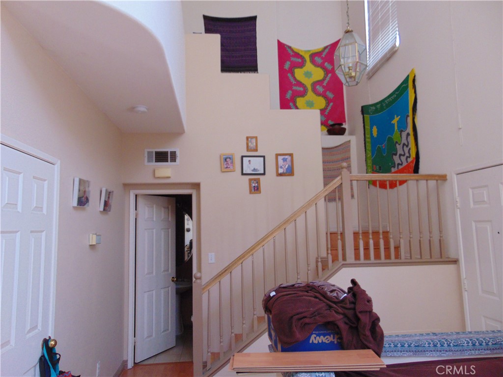 No common walls for two story home with amazing light from windows three stories high. End unit has full length of the home along the street which is uncommon in the tract. Tract at the top of the hill, end of the street. Easy access down the hill to 73 Toll road but no noise. Close to Shopping down Enterprise off Pacific Park. Living room is open to cathedral ceilings. Stairway and hallway to upstairs bedrooms overlook the living room for dramatic effect. Fireplace in the living room next to adjoining dining room. Kitchen opens off Dining room and is spacious with eating area breakfast nook in the corner. Kitchen has window overlooking patio and small yard with slider to Patio. Plenty of cabinets and on two sides of kitchen. Very functional and has gas stove and dishwasher and overhead microwave. Attached Garage opens to Kitchen. Half bath downstairs for ground level access. Laundry facility is in closet upstairs next to bedrooms. Master Suite has a walk-in closet and divided vanity. Windows everywhere... not a dark room in the house. Hall bath between two bedrooms for easy access. Repaired laminate flooring will be installed when tenant moves out prior to lease date. Home will be painted too upon negotiation. Paint by tenant is recent but not white.