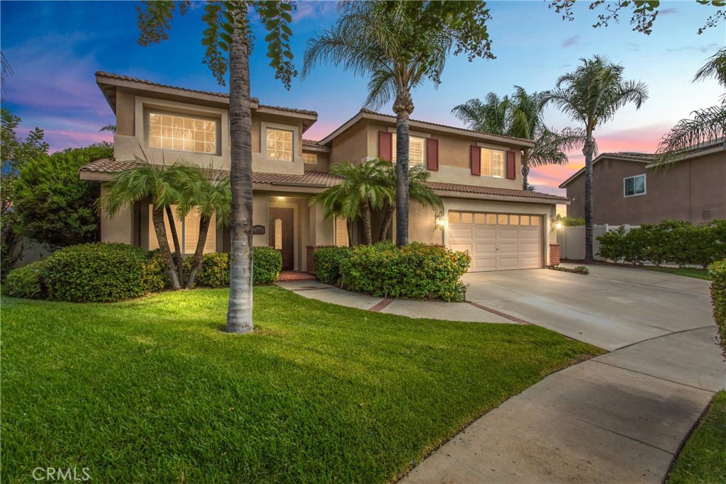 Situated at the top of a quiet cul-de-sac, this freshly updated home offers unobstructed city light views and plenty of living space both inside and out. As you enter, you’re welcomed by a formal living room with two-story ceilings and an adjacent formal dining room. Just off of the living room you’ll find one of the key features of the main level: a downstairs bedroom with brand new carpet, located next to a full bath with an updated granite vanity and walk-in shower—ideal for guests or multigenerational living. The laundry room, complete with countertops, cabinet space, and garage access, adds convenience. Plantation shutters, crown molding, and hardwood flooring extend through the main living areas, leading to the great room at the rear of the home, complete with a granite kitchen, stainless steel appliances including a gas range and dishwasher, a center island, and a breakfast nook. The adjoining family room offers a fireplace, ceiling fans, and sliding door access to the backyard.
Upstairs, new neutral carpeting has been installed throughout the main living areas. The oversized primary suite includes a sitting area with a gas fireplace, dual walk-in closets, and a freshly painted private balcony with city light views. The remodeled en-suite bath offers a vanity with dual sinks, an updated tile shower, and a soaking tub. You’ll find three additional bedrooms down the hall all with ceiling fans that share a centrally located full bathroom complete with double sinks and a shower/tub combo.
The private backyard is designed for entertaining with an outdoor kitchen space complete with a BBQ, refrigerator, and counter space, a covered patio with a ceiling fan, sparkling pool and spa, and a large grassy area with mature landscaping—all with expansive city light views.
Additional features include an oversized two-car garage with a built-in work station, gated RV parking, and NO HOA. Fresh interior paint and brand new carpet make this home move-in ready for its next owner. Conveniently located to nearby shopping, schools, and freeway access.