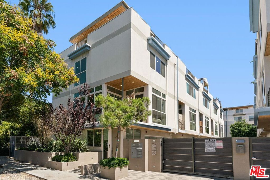 In the heart of Hollywood, just moments from the city's most storied streets, a sleek townhouse in the exclusive Hollywood Colony II community offers a modern take on Los Angeles living. Built in 2014, the residence balances architectural drama with everyday comfort. Inside, airy volumes are defined by 11-foot ceilings and floor-to-ceiling windows that capture the California light. The open kitchen, finished with Caesarstone countertops, custom cabinetry, and stainless steel appliances, is as well suited for intimate meals as it is for lively entertaining. Upstairs, the primary suite serves as a private retreat, complete with a generous walk-in closet and spa-style bath. Additional bedrooms each enjoy their own en-suite bathrooms, creating an ideal layout for guests or family with one bed and full bath downstairs. Atop it all, a private roof deck frames postcard-worthy views of the Hollywood Sign and the city skyline a reminder of the home's place at the center of it all. A direct-access two-car garage, in-unit laundry, and smart-home systems add convenience to the stylish design.Hardwood and tile flooring, central climate control, and energy-efficient features round out a residence that feels both contemporary and timeless.