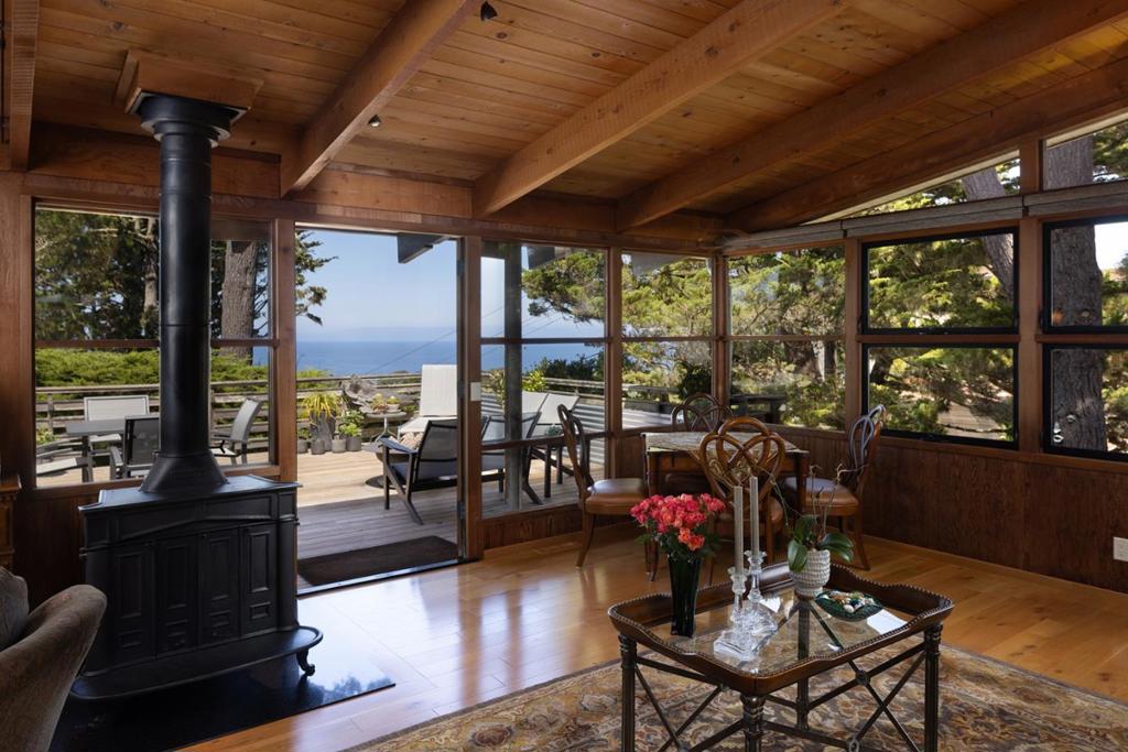 Perched on a hand-selected double lot with what may be the finest ocean views in New Monterey sits this architectural gem designed by famed local architect John Gamble, known for his mastery of seamlessly blending mid-century modern design with natural elements. Rarely does a home of this caliber and character come to market; only the third owners since its creation have lovingly restored and thoughtfully updated it, while preserving its timeless character. French doors frame sweeping views of the Monterey Bay and Pacific Ocean. Warm oak engineered wood floors flow through the main living spaces, complemented by the original cast iron fireplace now burning gas. The open floor plan centered around the view includes a remodeled chefs kitchen featuring granite counters, Wolf appliances, and new designer lighting, while a large deck with a built-in fire pit extends the living space outdoors for unforgettable sunsets. If the 3 bedrooms and 2 and a half baths aren't enough, there is a newly built ADU with ocean views, radiant heat, Caesarstone counters, full kitchen with custom cabinetry, ceramic tile floors, and a sleek bath ideal for guests, rental income, or extended family. Extra parking and a paver driveway accommodate both residences, along with two storage sheds for convenience.