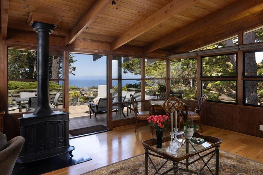 Perched on a hand-selected double lot with what may be the finest ocean views in New Monterey sits this architectural gem designed by famed local architect John Gamble, known for his mastery of seamlessly blending mid-century modern design with natural elements. Rarely does a home of this caliber and character come to market; only the third owners since its creation have lovingly restored and thoughtfully updated it, while preserving its timeless character. French doors frame sweeping views of the Monterey Bay and Pacific Ocean. Warm oak engineered wood floors flow through the main living spaces, complemented by the original cast iron fireplace now burning gas. The open floor plan centered around the view includes a remodeled chefs kitchen featuring granite counters, Wolf appliances, and new designer lighting, while a large deck with a built-in fire pit extends the living space outdoors for unforgettable sunsets. If the 3 bedrooms and 2 and a half baths aren't enough, there is a newly built ADU with ocean views, radiant heat, Caesarstone counters, full kitchen with custom cabinetry, ceramic tile floors, and a sleek bath ideal for guests, rental income, or extended family. Extra parking and a paver driveway accommodate both residences, along with two storage sheds for convenience.