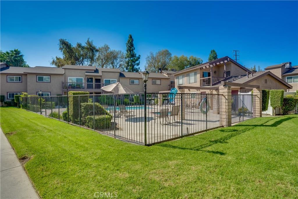Welcome to this adorable two bedroom condominium nested in the gated community of Pinetree Village. Front balcony overlooks the sparkling pool and club house. Step inside to a spacious living room. The kitchen has a sliding glass door leading out to a second balcony. Washer and dryer hook ups are in the kitchen area as well for added convenience. The master bedroom and living room have new ceiling fans with lights. Located just minutes from the 91 and 55 freeways, Metrolink, shopping and restaurants. Community features include gated entrance, pool, spa, clubhouse and extra laundry area.