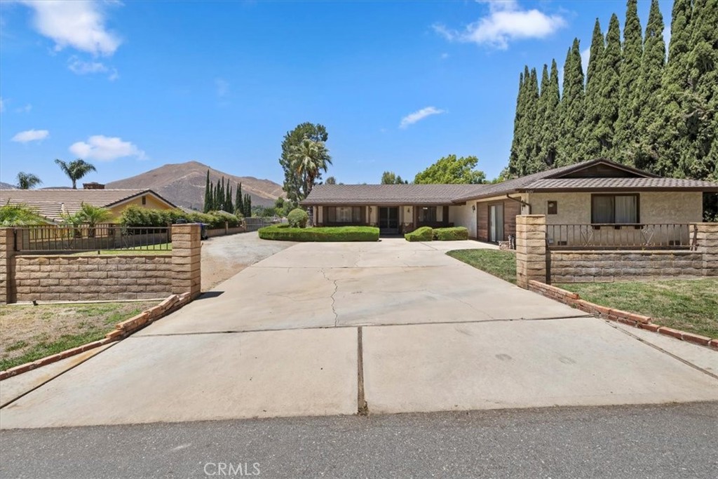 SINGLE STORY on just over a Half-Acre Lot with endless potential in the heart of Jurupa Valley. This spacious 4 bedroom, 2 bathroom home offers a rare opportunity to make it your own in the Benedict Estates. This large flat usable lot, which is also zoned as horse property provides plenty of space to park RVs, additional vehicles, or even create your dream outdoor retreat or workshop. The home, which has maintained its classic charm, features an open floor plan with generously sized bedrooms, each offering ample space for family or guests. The original garage was converted into a versatile bonus room, ideal as a 4th bedroom, home office, gym, or game room. Outside, the property boasts a detached workshop, perfect for a handyman, car enthusiast, or someone needing extra storage space. Whether you're looking to renovate or expand, the potential for this property is limitless. Located in a quiet, desirable area of Jurupa Valley, this home is minutes from shopping, dining, and major freeways, making it an ideal spot for those looking to enjoy country living with easy access to city conveniences.