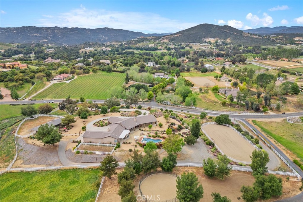Welcome home to this impressive Single Story Estate located in the Prestigious Exclusive area of La Cresta. This one truly has it ALL! ~ Main Estate ~ Guest Home ~ Horse Facilities ~ Pool ~ Spa ~ Outdoor Kitchen/BBQ Island & Stunning Panoramic Views! The MAIN HOME features 4115 ASF., TWO PRIMARY BEDROOMS w/ luxury bathrooms & walk-in closets, plus 3 secondary bedrooms, formal living & dining w/ wood burning fireplace, Gourmet Chef's kitchen w/ 6 burner Viking cook range, double Viking ovens, center island w/ warming drawer, microwave & dining counter, oversized stainless steel refrigerator/freezer, custom cabinetry w/ showcase doors, granite counter tops & spacious dining area, Spectacular family room open to kitchen w/ ceiling fan & wood burning fireplace, Inviting open floor plan complimented w/ beautiful hardwood flooring, crown molding, 8 Ft. solid wood doors & plantation shutters. The outdoors is perfect for entertaining from all aspects w/ a tropical pool & spa featuring 2 Baja steps, rock grotto waterfall's & expansive stone deck w/ fire pit. There is also an outdoor kitchen w/ 2 power burners, 38" BBQ, sink, refer & dining counter. The veranda ties it all together w/ lights & ceiling fans. The 500 ASF., GUEST HOME features a charming kitchen w/ cook top, oven, microwave, refrigerator, stainless steel sink, storage cabinets, sitting & sleeping area w/ ceiling fans, closet plus a beautiful 3/4 bathroom w/ shiplap wood accent wall. FOR THE HORSES there is a 4 Stall Breezeway Barn w/ turnouts, lights, ceiling fans, oversized tack room with sink & storage cabinets, paddock, estimated 100' X 200' Sand Arena, pasture & hitching posts. The ACREAGE is Brilliantly landscaped w/ Impeccable presence featuring stone walkways, sitting area's, stepping stones, raised garden bed, rock landscape gardens, lush mature tree's, plants & 24' x 64' vinyl fenced area. The entire property is completely fenced with TWO ENTRY GATES for added privacy! THE COMMUNITY ~ The La Cresta Life offers the perfect opportunity to enjoy country living at its finest with twinkling star filled skies, scenic open space, extensive private trail system, Santa Rosa Plateaus Ecological Reserve & lovely Community events! Located within minutes from all modern conveniences, award winning schools, restaurants, premier golf courses, shopping malls, hospitals, world renowned wineries, resorts & I-15 freeway. Less than 1.5 hours from LA, San Diego, Palm Springs, Beaches, Mountains & Theme Parks!
