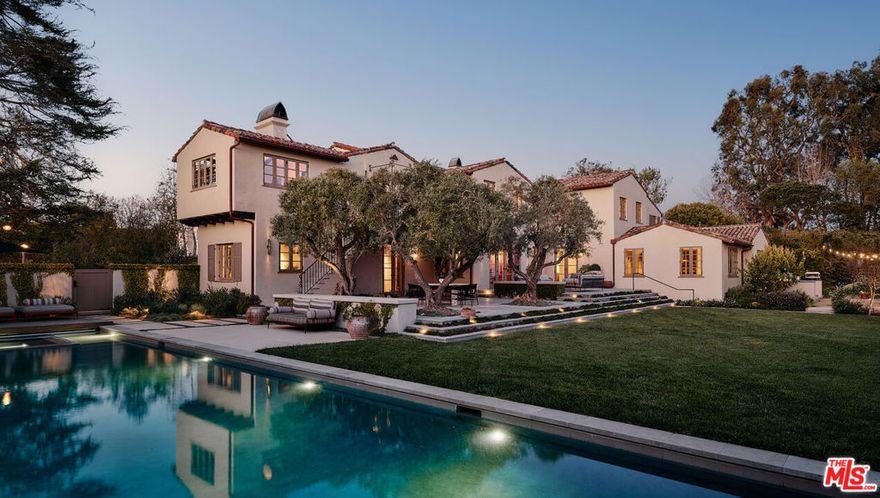 The Parry Residence c. 1929, by Gable & Wyant.  A rare landmark property and the second home to be constructed in the Huntington Palisades. This 1929 Monterey Revival estate, prominently featured in the Architectural Digest issue of 1930, has been masterfully reimagined while preserving its historic integrity. Set on a double lot totaling 25,265 square feet, the residence spans 7,355 square feet, with an additional 1,033-square-foot Aman-inspired wellness pool house. The interiors, designed by Clements Studio and Estee Stanley, pay homage to the home's artisanal heritage, featuring hand-painted ceilings, intricate pocket doors, and a thoughtful mix of materials that create a tactile experience at every turn lending the interiors their depth and timelessness. Arched passageways, decorative ironwork, and hand-carved woodwork harmonize with the home's modern updates. The formal living room is anchored by a richly veined marble fireplace and coffered ceiling highlighting a bespoke light fixture by William Waterhouse. The dining room boasts hand-applied chinoiserie wall treatments, while the kitchen features custom oak cabinetry and honed stone countertops paired with a butler's pantry and integrated banquette seating that overlooks the grounds designed by renowned landscape architect Mark Rios. Here, a secluded garden retreat weaves together a tapestry of olive trees, a fern garden, and a stately Deodar cedar. The resort-like backyard offers an expansive chef's garden, multiple outdoor dining and lounge areas, a 62' pool and jacuzzi. A private path leads to a serene, light-filled wellness pool house with two full baths, a sauna, gym, and entertaining area. The main residence's primary suite is situated to capture sweeping 180-degree views of the Pacific. It includes a sitting room, a Juliet balcony, and a marble-clad bathroom with a freestanding tub, dual vanities, and an oversized walk-in wardrobe with integrated lighting and custom millwork. Additional amenities include a terracotta-toned screening room with built-in media cabinetry, a temperature-controlled 800-bottle wine cellar, and a custom crafts and study space with ample storage and natural light. This extraordinary estate presents one of the Palisades' most important architectural restorations, offering a residence rooted in heritage, incomparable design, and modern luxury without compromise. Learn More at 14924camarosa.com