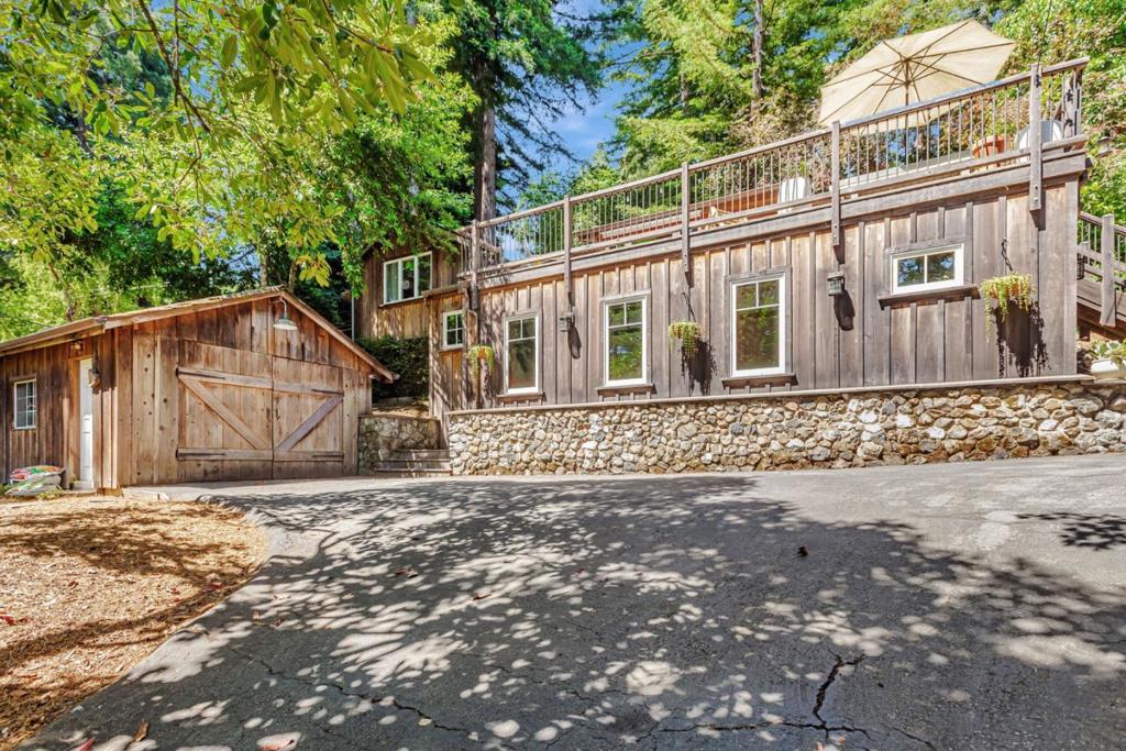One-of-a-kind mountain retreat on a sun-drenched, fenced 1/3-acre lot surrounded by majestic redwoods. This charming 1930s log cabin has been thoughtfully expanded with a quality newer master suite addition. Features include vaulted ceilings, radiant heated hardwood and tile floors, dual-pane windows, and an open kitchen with granite counters and a new six-burner gas range. Enjoy serene views and all-day sunlight from the expansive south-facing deck. The detached garage includes an EV charger, attic storage, and parking for multiple vehicles. Landscaped with drought-tolerant native plants. Located within walking distance to Alices Restaurant, Skywood Trading Post, and miles of scenic hiking and biking trails. Easy access to Skyline Blvd and Hwy 84 for a smooth commute to Silicon Valley or the coast. Classic charm meets modern comfort in a peaceful, tight-knit communityperfect as a full-time residence or weekend getaway.