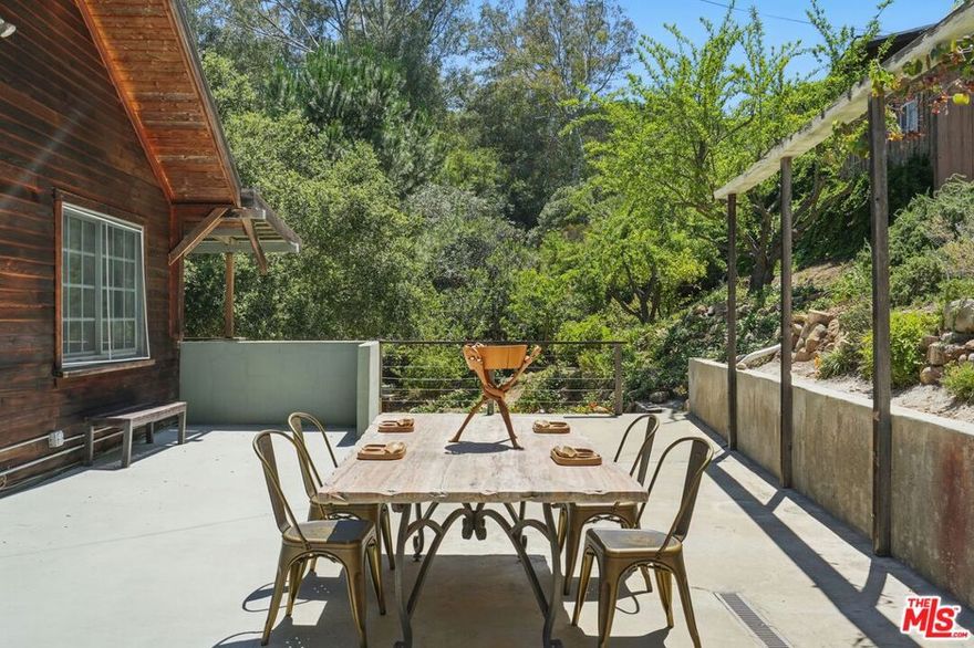 Tucked away in the desirable Fernwood neighborhood of Topanga, this rare and versatile property offers a unique blend of charm, privacy, and creative potential. Set on a beautifully landscaped, fully fenced, dog friendly oversized lot up a private driveway, this home is surrounded by mature oak trees and lush gardens, creating a serene retreat with a true sense of seclusion. The main residence features two spacious and flexible living units, each filled with natural light and boasting its own private entrance, full kitchen, open dining area, large full bathroom, and expansive indoor-outdoor flow via upper and lower decks and patios perfect for entertaining or enjoying the tranquil canyon breeze.   Use the units separately for multi-generational living, guest units, or combine them into one cohesive home through the interior staircase to suit your lifestyle. In total, the home offers four bedrooms and two bathrooms, with thoughtful layouts and seamless integration of indoor and outdoor spaces. Separate laundry areas for the main house and guest house provide added convenience and privacy. Adding to the property's versatility is a stand-alone studio cottage, complete with front and rear patios, its own laundry, full bath and kitchen adds endless potential as a guesthouse, rental unit, art studio, or home office. Additional features include: Approx 24 Solar panels.  A shipping container ideal as a workshop or secure storage. Two additional storage sheds, mature landscaping and multiple outdoor living areas with iconic Fernwood breezes brings a true connection to nature. Whether you're looking to live, work, create, or invest, this Topanga gem offers the space and flexibility to make your vision a reality. Come experience the harmony of light, nature, and possibility in the heart of Fernwood.