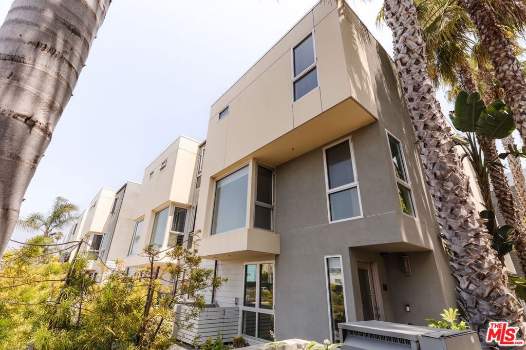 A premier canal-facing corner townhome showcasing stunning water views and elevated finishes, just moments from the beach. This 4-bedroom, 3-bath residence offers a thoughtfully designed floor plan filled with natural light and timeless elegance. As a corner end-unit it feels like a single family home, enjoy the privacy of no neighbor on one side, with expanded windows and serene views throughout. Step outside to walking trails along the canal, or relax on the sun-kissed patio facing the water, perfect for enjoying evening sunsets. The open living space features custom walnut built-ins, a sleek fireplace, and a chef's kitchen with breakfast bar & top-of-the-line appliances ideal for both effortless entertaining and everyday living. The tranquil primary suite offers spa-caliber amenities including a steam shower, jetted soaking tub, and Toto fixtures. Oak hardwood floors, curated lighting, updated closets, and inside laundry add to the home's thoughtful design. Additional features include a private direct entry two-car garage with EV charging, guest parking, on-site gym, and concierge. Ideally situated in Marina del Rey closest to Venice, this home offers unmatched access to coastal trails, Abbot Kinney dining, and vibrant Westside living. This is So-Cal coastal living at its finest elevated, effortless, and unforgettable.