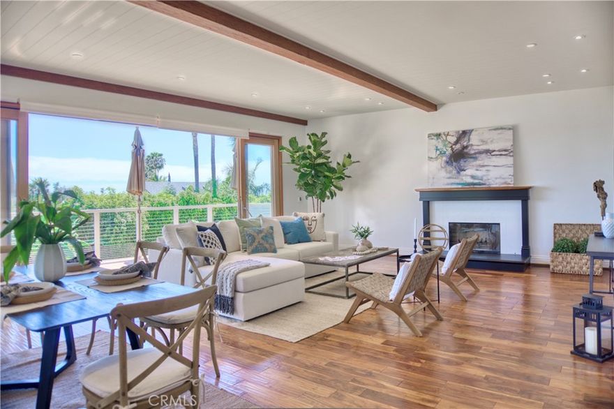 Beach living and sophistication at it's best in this Custom Capo Beach charmer. Sexy and Sleek, every detail of this home is unique, curated by award winning architect Brad McDonald.  Mahogany sliding doors fill the home with natural light embracing seamless indoor to outdoor living. Your new home offers the perfect southwest orientation with opulent ocean vistas and sparkling sunsets. Expansive kitchen is highlighted by a  wood paneled ceiling shaped as the hull of a boat . Featuring white cabinets and accented by  glass doors, concrete and stainless countertops, brand new stainless refrigerator and range. Designer inspired tile backsplash brings warmth and personality. Two spacious bedrooms and bath are located on the first level, no stairs. Beautiful Acacia wood floors throughout create a smooth transition.   On the lower level the Zen primary suite is enhanced by the sliding Mahogany doors welcoming you to a  lush paradise including  custom pool, spa and  expansive garden. The primary includes a fireplace and walk in closet.  Pristine primary bath has large soaking tub, dual sinks, and walk in shower all enriched by custom tile.  Adjacent to the primary is a large room with a view, offering an office, nursery, fourth bedroom, or a large closet, extra storage room too. Laundry room is equipped with Bosch washer and dryer lots of storage and sink.  Freshly painted and immaculate, possessing as a bonus wholly owned Solar with 220 in the garage ready for your EV.  Centrally located a quick bike ride to the beach, or catch the trolley from Sunset park. Walking distance to grocery, restaurants, and specialty shops make Capo Beach your home!
