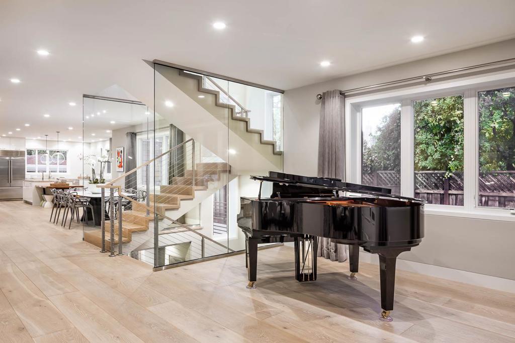 Custom construction completed in 2018, this award-winning 5-bedroom, 5-bathroom gem is sleek and sophisticated behind the quiet luxury of a traditional facade. Light-filled interiors showcase a sophisticated contemporary aesthetic with expansive open spaces and custom finishes throughout. White oak floors extend across all three levels, which are connected by a dramatic glass-wrapped floating staircase that serves as a striking centerpiece. The main level offers seamless flow between formal and casual living areas, a modern all-white kitchen with quartzite finishes, and a dedicated office (can be converted to a bedroom) with adjacent bath. Upstairs, three luxurious bedroom suites include a serene primary retreat with a private balcony and spa-inspired bath. The lower level is designed for entertainment and wellness with areas for recreation, media, and fitness, a future wine cellar, and two bedrooms and two baths. Gated off-street parking, a spacious outdoor cabana with heaters, and eco-friendly synthetic lawns in the front and rear complete this exceptional home in Old Palo Alto, less than a mile from University Avenue shops and restaurants.