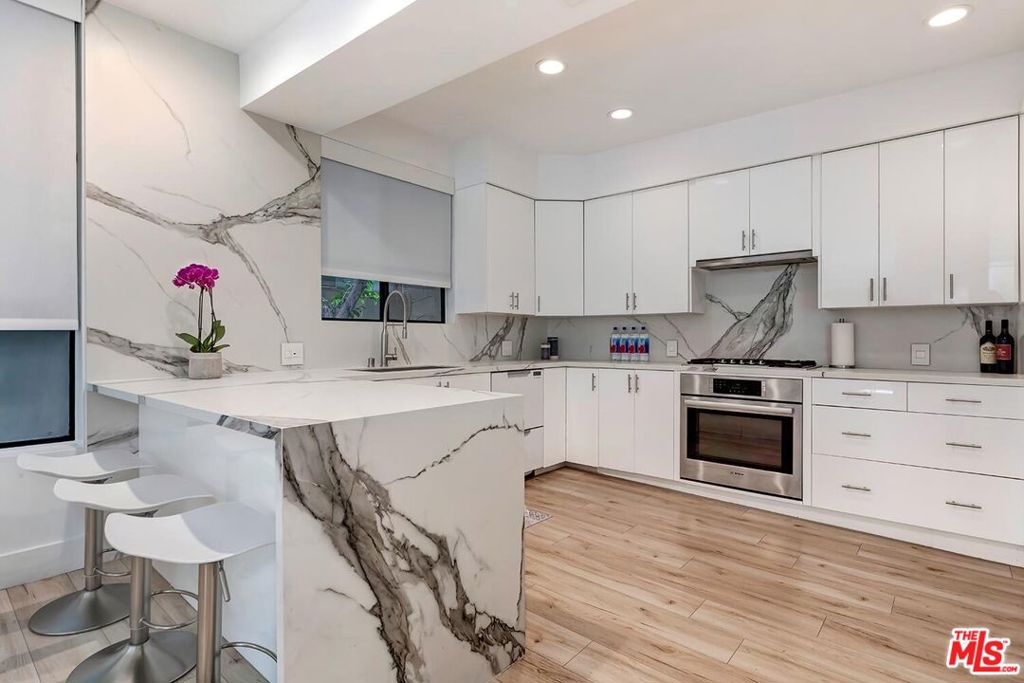 Located in a desirable Brentwood residential neighborhood, move in ready, blending sophisticated design with stylish comfort. Thoughtfully curated with custom detailing and elegant finishes throughout, offering a unique and modern experience. The spacious living room boasts an open floor plan, sleek BoConcept built-in wall unit, beautiful light wood floors throughout, open-concept kitchen features striking Calcutta porcelain countertops and backsplash, custom cabinetry, breakfast bar overlooking an expansive dining area ideal for entertaining. The chic primary suite showcases floating cabinetry, a custom-designed built-in closet in addition to a walk-in closet with a spa-inspired bathroom complete with an oversized shower, freestanding soaking tub, and beautifully crafted vanity, Second room is currently styled as an office/den. Easily converted to 2nd bedroom to suit your lifestyle with sleek designed glass doors with remote custom roller shades. In unit laundry room provides generous storage cabinetry, gated garage parking for two vehicles and dedicated storage. Located just moments from Brentwood's best-premier dining, boutique shopping, Montana Avenue or a quick stroll to the vibrant farmers market, home delivers the Westside community lifestyle, minutes from the beach, 12 unit bldg., secured access. pets allowed.