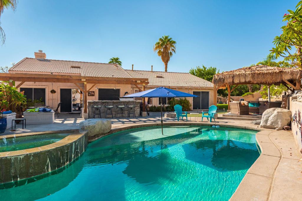 This North La Quinta home, enjoyed by its original owners, sits on an oversized 13,939 sq. ft. lot, offering plenty of room for an ADU or additional outdoor living space. Inside, you'll find 4 bedrooms, plus a bonus room off the primary suite, 2.5 bathrooms, and a 3-car garage. The light and bright kitchen features leathered quartzite countertops and generous storage, while newer interior paint gives the home a fresh, updated look. The backyard is designed for both relaxation and entertainment, featuring a 52' x 18' pool with a 9.5-foot depth and a safety fence, rock waterfall, a spa with an infinity edge, rock speakers, a gazebo, a custom BBQ island with seating, and custom outdoor lighting that enhances the space at night. Practical upgrades include RV parking with water and sewer plumbed and available on the side yard and a MyQ smart garage system for added convenience. Located just a short drive from the Empire Polo Grounds--home to the Coachella and Stagecoach music festivals--and the Indian Wells Tennis Garden, this home is also part of the Desert Sands Unified School District, making it a great choice for families or seasonal residents alike.