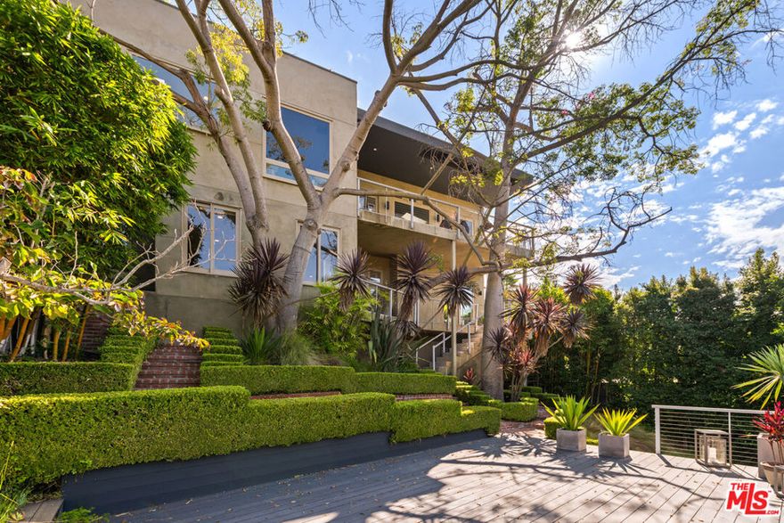 Set in a tranquil Beverly Hills PO location, this contemporary architectural masterpiece combines privacy, comfort, and stunning views of the ocean, Catalina Island, sparkling city lights, and the Getty Museum all while remaining easily accessible. Perched just above the city on a coveted street-to-street lot, the home offers seamless indoor-outdoor living with expansive balconies, lush gardens, and space for an infinity-edge pool or private ADU with its own entrance. Walls of glass, skylights, and floor-to-ceiling windows flood the interiors with natural light. The grand living room is perfect for entertaining, while the open-concept chef's kitchen features a 9' x 4' island, Bisazza glass tile backsplash, Cesar stone countertops, and top-tier stainless steel appliances.The luxurious primary suite includes a spa-like bath with steam shower and custom walk-in closet, complemented by three additional en-suite bedrooms, including a private guest suite with separate entrance. Offering prestige, privacy, and unmatched views without being far above the city, this estate delivers the ultimate Beverly Hills lifestyle.