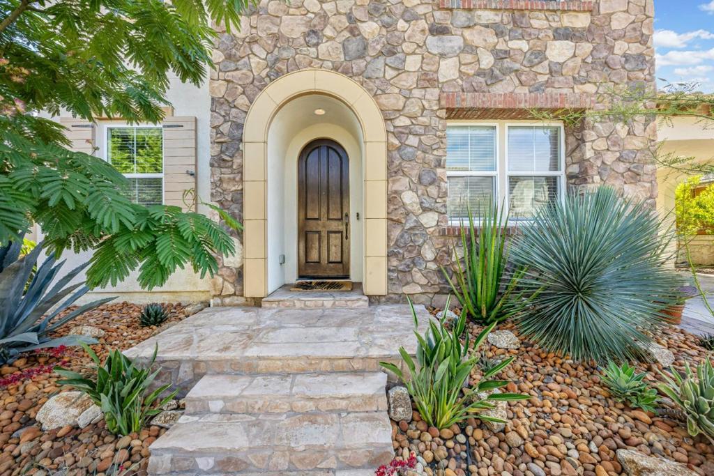Located in the gated community of Eagle Ridge, this highly sought-after Shapell Mariposa floorplan offers 3,191 sq ft living space with 4 bedrms and 3 full baths. A flagstone walkway welcomes you, framed by a professionally designed drought-tolerant succulent garden. Inside, soaring ceilings in the dining & family rooms create an expansive, airy feel. Recently upgraded white oak hardwood floors flow seamlessly throughout. The gourmet kitchen boasts marble countertops & backsplash, an oversized island with waterfall edge, and a professional-grade Wolf cooktop & oven, perfect for providing both function and style. The kitchen opens to the family room and nook, ideal for everyday living & entertaining. From nook, step outside to the flagstone finished courtyard, extending the living space. A 1st floor bedrm with adjacent renovated bath is perfect for guests or extended family. The laundry/mudrm includes a sink, cabinets, & backyard access. Upstairs, a loft finished with ornate wrought iron railing overlooks the living space below, enhancing the open layout. The private primary suite features French doors to a balcony above a secluded courtyard. A large backyard with mature trees & a built-in BBQ offers the ultimate outdoor retreat. ASSUMABLE VA loan for the right buyer!
