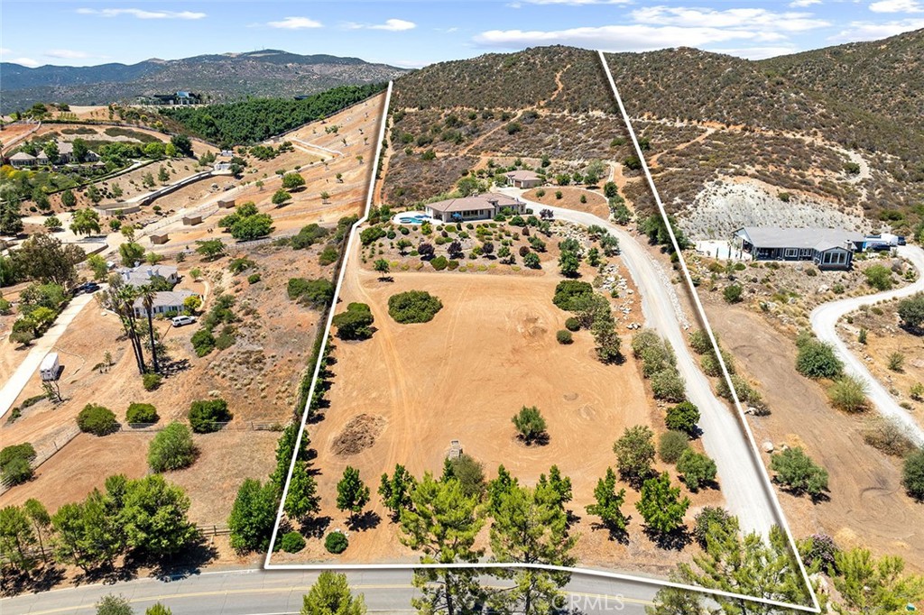TWO HOUSES! BOTH SINGLE-STORY! …ON 10 ACRES IN THE HEART OF LA CRESTA! Built in 2017, these two homes create the perfect family compound with a total of 4267 sq ft of living space (main house 4BD/3BA 3050sf …PLUS…2nd house 2BD/2BA 1217sf with full garage), perched on a knoll with forever views of the La Cresta Valley and local mountains. Both are single story with proximity to each other, yet each with a peaceful sense of privacy. If you don’t use the 2nd house for family & friends, consider the rental income opportunity. Strategically located off the main house, the pool with stunning views is close enough to be shared with the 2nd home. At the front of the property is a nice portion of very usable land, which can serve many purposes, such as the current dirt track for the kids, installation of a vineyard/orchard, further outbuildings (workshop, barn, etc…), horse pasture or arena. Nearby are community recreational/horse trails, as well as trails throughout the 10 acres, so you can ride and play directly on property! The homes are meticulously constructed and in excellent condition. Imagine the gatherings in the main house with its wonderful floorplan, including a dedicated office and inviting Great Room opening to a massive Chefs’ kitchen with island, peninsula, high-quality appliances, and forever views through the wall of glass. The covered patio welcomes you to the pool area, all just steps from the interior entertainment spaces. This property checks so many boxes: Excellent La Cresta location, 2 houses, expansive views, usable land, privacy, newly built with fantastic amenities, and lovely touches, such as the raised gardens and a plethora of trees. *****Discover the Santa Rosa Plateau Lifestyle…5-acre minimum parcels (10-acre minimum. in SR West), just minutes to schools, restaurants, hospitals, grocery stores, 15 Fwy & Temecula Wine Country. Enjoy this peaceful ranch community w/no commercial businesses, robust social activities, miles of private community trails & 1000s of acres of Ecological Reserve…All less than 1.5 hours from LA, SD, OC, Palm Springs & Big Bear. Discover the country, yet convenient, lifestyle of La Cresta, Tenaja & the Communities of the Santa Rosa Plateau!