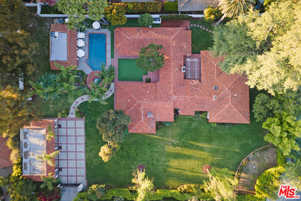 **** PLEASE CALL TO SCHEDULE SHOWING and AGENT SEE REMARKS ON PRICING****. Rarely does timeless elegance merge so effortlessly with modern luxury as in this iconic 1923 Spanish Hacienda Estate--- once part of historic Rancho Mission and owned by Edgar Rice Burroughs. Nestled on a rare, flat, park-like acre, this gated 6-bed, 9-bath, 6,180 sqft compound is a private sanctuary embodying the romance of a bygone era and the essence of classic California living. Fully walled and gated, the estate opens to a double-wide motor court and spacious four-car garage. Meandering paths lead through lush gardens, fountains, expansive lawns, and a guest home. At its heart, a resort-style pool evokes the magic of old Hollywood. *** The single-level hacienda, centered around a serene courtyard, celebrates the indoor/outdoor lifestyle. Inside, warm architectural details and expansive spaces create an inviting setting for both grand entertaining and relaxed living. A full-wall fireplace with bold brick design anchors the grand living room, enhanced by beamed and paneled ceilings and classic French doors that flood the space with light and sunning views of the grounds. *** The oversized dining room opens to the inner courtyard, while the newly remodeled chef's kitchen is a showstopper anchored by a stunning 16-foot Calacutta marble island, matching marble countertops, custom cabinetry, and top-tier appliances, including a Viking 8-burner range with double ovens, 2 dishwashers, triple basin Franke Stainless Steel sink, and an array of countless premium upgrades. Framed by floor-to-ceiling steel French doors, the room offers breathtaking views of the grassy courtyard and sparkling pool. *** The expansive primary suite is a serene retreat with a brick-arched fireplace, spa bath, sitting room, and private office. A colonnade leads to three oversized ensuite bedrooms, a fourth bedroom or library, a private office/gym, and oversized full media room overlooking the inner courtyard. *** Step outside and experience the vast, simply unmatched grounds--- like having your very own private park! From charming alfresco dining areas and multiple patios ideal for lounging or entertaining, to a sprawling Great Lawn that effortlessly accommodates everything from playful afternoons to the grandest of holiday gatherings and timeless celebrations. The show-stopping pool, nestled under 19 swaying palms, evokes classic Beverly Hills glamour. An impressive guest house with its own courtyard and yard completes the retreat and offers endless expansion possibilities. *** Secreted away, this extraordinary timeless estate stands as one of the area's most exceptional and rare offerings. A true one-of-a-kind compound that echoes the charm of a bygone era, it showcases distinctive architecture, unrivaled privacy, and a breathtaking natural park-like setting. From the moment you arrive, you're transported to a world all your own. A rare offering like none other, this estate must be seen to truly appreciate.