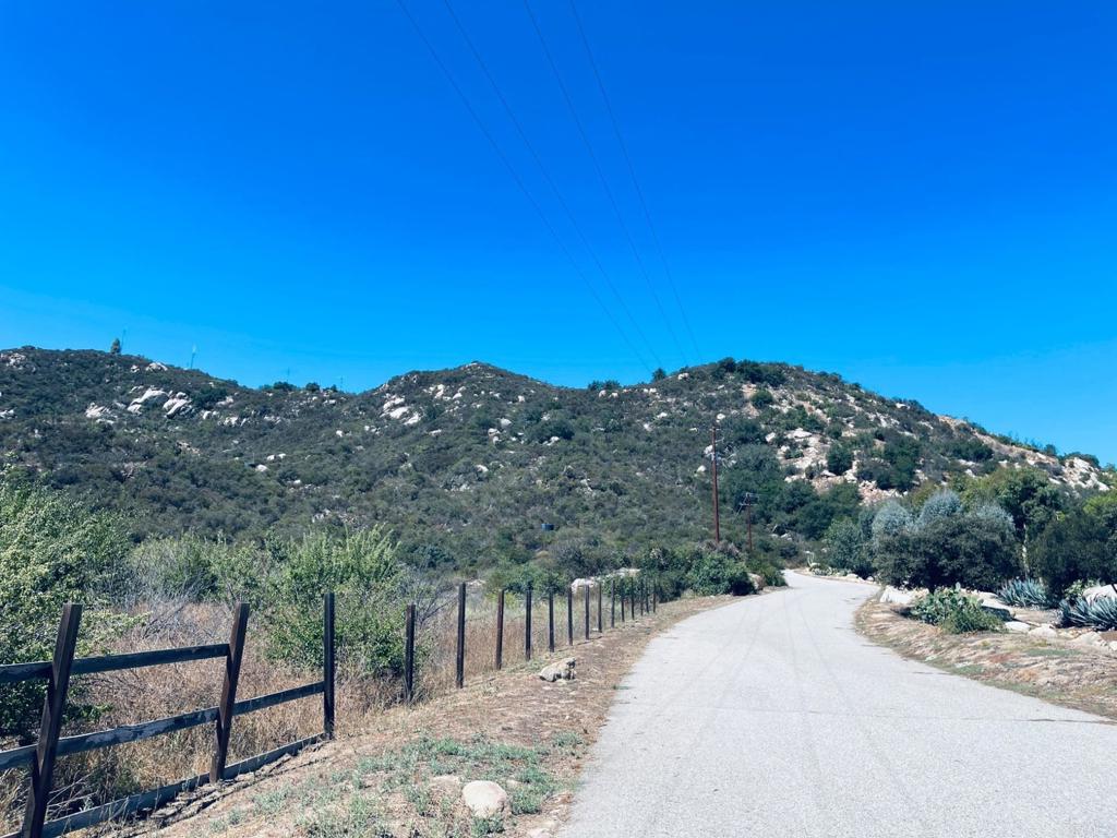 A rare opportunity to own over 68 acres in Rainbow Heights, Fallbrook, offered as three separate parcels with endless potential. This unique property is perched high above the valley, showcasing panoramic views of Pauma Valley, Palomar Mountain, and out to the Pacific Ocean. Rough cut building areas sit along the ridgeline, offering excellent locations for a custom estate, retreat, or family compound. The land includes approximately ten acres of gently sloping and flat terrain on the northeastern side, with agricultural potential. A 40’ x 22’ metal building with three connected cargo containers provides a workshop and abundant storage space. Additional infrastructure includes one 10,000-gallon and three 5,000-gallon water tanks, a 1” water line connection, and electricity available at the street. Rough-cut roads connect multiple access points across the property, though re-grading will be needed. Zoned Agricultural, the property supports a wide variety of potential uses — from equestrian facilities and farming, to vineyards, homesteading, or even a private retreat or glamping site. Just minutes from I-15, yet surrounded by the privacy of Fallbrook’s rolling hills, this property combines accessibility with space and seclusion. ? All information deemed reliable but not guaranteed. Buyer to verify all.