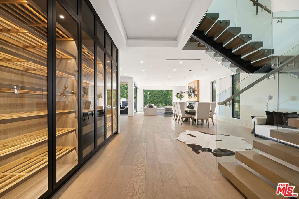 Nestled in the heart of West Hollywood, this Fully Furnished newly-crafted smart home is a symphony of refined elegance and cutting-edge innovation, harmoniously blending organic warmth with contemporary sophistication. Designed as a haven for grand entertaining and bathed in natural luminescence, the residence offers a flawlessly fluid layout adorned with curated finishes that epitomize the quintessence of Southern California's enviable indoor/outdoor lifestyle. The master suite serves as a sanctuary of romantic opulence, replete with dual bespoke walk-in wardrobes, an intimate fireplace, a sumptuous private balcony, and a spa-like en suite bath. Additional refined amenities include a secluded home office, a wine cellar capable of housing a 270-bottle collection, a distinguished piano lounge, and an elegant formal dining chamber. Pocket doors grace the interiors, enhancing the spatial flow, and an upstairs family/media salon adds a touch of familial warmth. The gourmet chef's kitchen stands as a testament to culinary artistry, furnished with Italian marble countertops and outfitted with the crme de la crme of modern appliances. Step into your personal Zen-inspired oasis in the backyard, complete with a tranquil pool and spa, or ascend to your private rooftop terrace. Here, a built-in BBQ awaits, setting the stage for unforgettable sunset soires beneath a tapestry of stars.