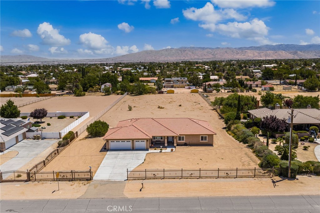 Situated on a 57,935 square-foot groomed and gated lot with a paved street and in a quiet neighborhood, this Hesperia one story retreat with two master retreats exemplifies "True Pride of Ownership". Exterior features include Fresh complementary exterior paint scheme, groomed grounds, and custom front gate enhances this homes curb appeal. As soon as you walk in, you are greeted with high ceilings, a flowing 2,523 square foot open concept floor plan that is "Turn-Key" with striking architectural accents, fresh interior paint, recessed lighting, and a complementary blend of tile in the kitchen and bathroom areas, New Luxury Vinyl in the main living areas, and plush carpet flooring in the bedrooms. The kitchen invites you to cook your favorite meals with its sleek built-in stainless steel appliances, Dual ovens, 5 burner cooktop, Granite countertops, Walk-in pantry, and large peninsula with seating for 6 at the breakfast bar. The abundance of cabinetry and counter space ensures the kitchen is both functional and beautiful. You’ll find it easy to serve and entertain your guests simultaneously while creating the perfect ambiance. From the kitchen, the recessed lighting gently lights the dining room, and the adjoining family room. Designed for easy living and entertaining, This home features a spacious living room, a cozy gas burning fireplace framed by a stylish stacked stone hearth. A laundry room with plenty of counter and cabinet space and direct access outside. with a total of 4 bedrooms, two of which are master retreats and a total of 3 full bathrooms. Each bedroom has its own lighted ceiling fan. Energy efficient dual pane windows and lighted ceiling fans throughout will help keep your utility bills low and the interior very quiet and comfortable year round. Step outside into your private gated backyard oasis with an oversized covered patio, low maintenance landscaping, privacy fencing, and plenty of parking in the oversized driveway, the giant 3-car garage, RV parking, and or off street parking. This lot is a blank canvas. It would be perfect for those who are looking for peace and quiet or need a place to park their trucks and toys. This home will allow you to do anything that your vision permits. Close to all shopping, dining, and freeway access.