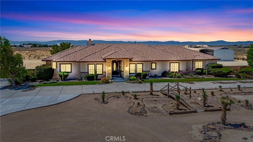 Live the Dream in this Custom Mediterranean Ranch-Style Estate! Set on a Fully Usable 2.52-Acre Lot, this Beautifully Designed Single-Story Home Offers Nearly 3,000 sq ft of Luxurious Living Space with 4 Spacious Bedrooms & 3 Bathrooms. Built in 2008 with No Expense Spared, it Blends Timeless Architecture with Modern Comforts. Upon Entry, You're Greeted by a Grand Open Living Area with 20-Foot Ceilings, a Striking Italian Stone Feature Wall, & a Cozy Wood-Burning Fireplace. The Expansive Kitchen is Designed for Entertaining, Featuring Granite Countertops, Bar Seating for Seven, Rich Wood Cabinetry, Stainless Steel Appliances, & a Massive Walk-In Pantry. The Home Showcases Travertine Flooring Throughout the Central Living Spaces, Plush Carpeting in the Bedrooms, & Plantation Shutters Throughout. The Luxurious Primary Suite Spans One Side of the Home & Offers Two Private Patios, a Spa-Inspired Bathroom with Dual Granite Vanities, Soaking Tub, Custom Walk-In Shower, & a Generous Walk-In Closet. Three Additional Bedrooms are Located on the Opposite Wing, each Spacious Enough to Include a Desk or Workstation. A Dedicated Home Office Near the Entry Provides Plenty of Space for Remote Work. Comfort Features Include Central Air & Heat as Well as an Industrial-Grade Swamp Cooler Ducted Throughout. Outside, the Backyard is a True Entertainer's Paradise, with Custom Concrete & Stonework, an Outdoor Kitchen with Bar Seating, Firepit, Landscaping, & Expansive Lawn Areas. The Oversized Garage Easily Fits Multiple Vehicles, While the 32' x 50' Barn Offers Ample Room for RVs or Heavy Equipment. To Top it Off, the Front Yard Features a Custom Handcrafted Wooden Bridge & Dry Riverbed, a One-of-a-Kind Touch. This Special Property Offers Style, Space, & Serenity.