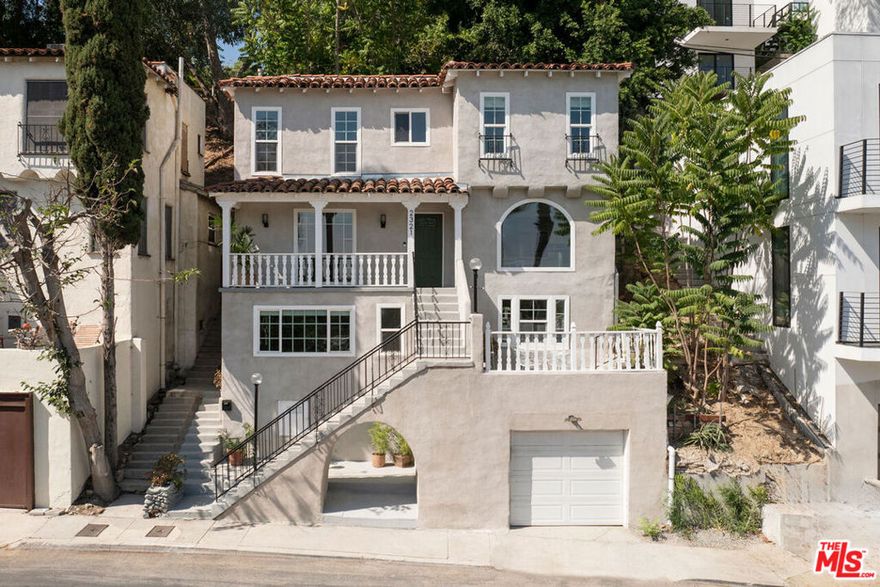 Silver Lake living feels exquisite in this 1930 Spanish, reimagined with modern sensibility and enjoying sweeping hillside views. The tri-level layout balances original charm and smart updates, featuring bright, airy rooms with effortless flow. In the living room, a large picture window frames the hills in golden light; the dining room centers on a grand arched window, a perfect backdrop for gatherings. The open kitchen is finished with waterfall quartz counters, stainless appliances, counter seating, and abundant storage. Three bedrooms and two updated baths provide versatility, including a lower-level suite with private entrance, full bath, and laundry, ideal for guests or creative work.Lush outdoor space expands across multiple terraces: a deck above the garage for sunset cocktails, a rustic stone patio for relaxing, and a serene garden retreat.From this street-to-street lot, enjoy proximity to the Reservoir, Meadow, Silver Lake Wine, Whole Foods, and local favorites along Glendale Boulevard.