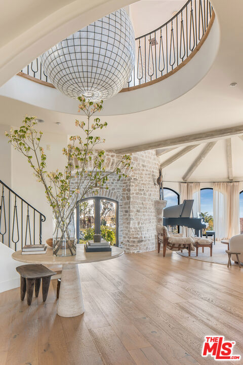 Timeless Elegance in the Enclave of Pacific Palisades! Designed by Katie Hodges, this fully remodeled 4-bedroom, 6-bathroom estate blends refined interiors with resort-style living in the exclusive gated Enclave. The thoughtfully designed layout includes an en-suite guest bedroom downstairs and a luxurious upstairs primary retreat with sweeping views, spa-like bath, plus two additional bedrooms and a large bonus room. Set on over half an acre with tastefully designed manicured grounds, the home features Venetian and European plaster, White Oak floors, Calcutta Gold kitchen countertops, Sub-Zero and Wolf appliances, Waterworks/Kallista fixtures, and custom built-ins. The outdoor oasis includes a resurfaced 50-ft lap pool with Baja shelf, updated spa, fire pit, Al Fresco kitchen including bbq, pizza oven, refrigerator with bar seating and redesigned lighting.The approx. 2,000 sq ft epoxy-coated garage fits 6 cars and includes a Tesla charger, wine cellar, gym/music room, and extra storage. Additional upgrades: Control4 system, water filtration, security cameras, integrated speakers, 4 HVAC zones with air scrubber, and designer finishes throughout. A rare and refined retreat just minutes from the beach & all that West coast living has to offer.