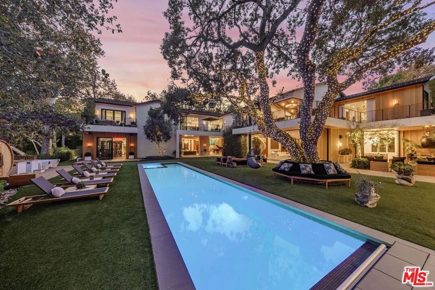 This prized blue-chip estate designed by the renowned Jae Omar is one of the finest offerings in Los Angeles. Situated on nearly one serene acre, and nestled behind gates amongst majestic Oak Trees, the property boasts tremendous natural beauty and privacy. Upon entering the home, you can't help but admire the impeccable design and craftsmanship, inspired use of organic materials, impressive scale, and indoor-outdoor flow which maximizes usability of the estate's grounds. The expansive living areas include a gourmet kitchen and breakfast room, grand family room, dining area, spacious gym, home office, and authentic pub. A secluded rear yard features verdant lawns, relaxing patio spaces, putting green, outdoor kitchen and barbeque, and an inviting swimmer's pool. Experience a luxurious primary suite with spa-like bathroom, massive dual walk-in closets, and a wrap-around terrace with views of the surrounding Oak Trees. Additional amenities include a wellness area with gym, sauna and massage room, professional music studio and vocal booth, state-of-the-art home theatre, security booth, secondary catering kitchen, wine cellar, raised garden beds, and five guest bedrooms all with ensuite bathrooms. Since its completion in 2019, the property has continuously been upgraded, and is truly a world-class estate.