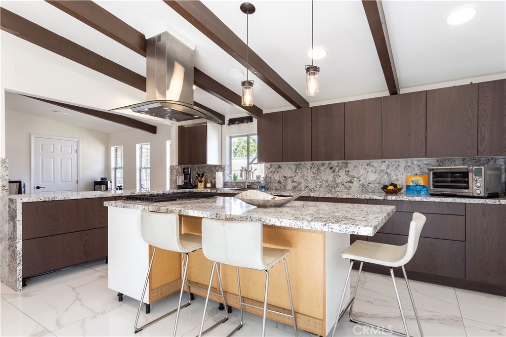 This beautiful Mid-Century home is nestled on a quiet picturesque street in one of Reseda’s most sought-after neighborhoods, and was designed by one of Los Angeles’ most renowned architects, Edward Fickett. Here are just a few of its many other fine features: NEW CUSTOM DESIGNED KITCHEN, NEW MAIN BATHROOM. Mature shade tree, lush landscaping, planters filled with a myriad of rose bushes, and groomed shrubbery you’ll immediately recognize the true “Pride-Of-Ownership” Custom double doors open to a flowing 1,355 square foot open concept floor plan that is in “Move-In-Condition” with HIGH WOOD BEAMED CEILINGS, NEW RECESSED LIGHTING, a designer paint scheme, and the complementary blend of newer laminate and tile flooring. The spacious living room is bathed in natural light from a huge picture window, and complemented by a gas-burning fireplace with custom tiled hearth. Any gourmet cook will truly appreciate the beautifully NEW kitchen’s abundant soft close cabinets, ample granite counters with full back-splash, center island with custom pendant lighting and built-in wrap around breakfast bar, deep basin steel sink with custom faucet, newer built-in stainless-steel appliances, gas cook-top with contemporary glass/stainless steel ventilation hood, plus the convenience of the very large adjoining dining area. A total of 3 bright and spacious bedrooms. 1¾ beautifully appointed bathrooms. Functionally located laundry room. Energy efficient dual pane windows will help keep your utility bills low and the interior very quiet. Central heat & air for year-round comfort. You’re going to appreciate and enjoy the large backyard’s tall privacy fencing, patio, and the 2 very handy storage sheds. Plenty of secure off street parking for all of your vehicles and other toys on the oversized concrete driveway and under the large carport. All of this sits on a large 7,500 square foot lot that’s within walking distance of Melvin Elementary School, and minutes away from the Orange Line Busway, Pierce College, Topanga Mall, The Village at Topanga, and Warner center with its entertainment and myriad of gourmet restaurants.