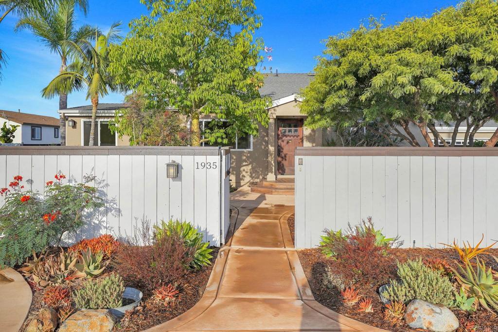 Welcome to 1935 Berry Street in Lemon Grove—your own private oasis in the heart of the city, where serenity, space, and thoughtful design come together in a one-of-a-kind retreat you simply can’t miss. From the moment you arrive, the gated entry reveals a lush landscape cultivated over decades, offering a sense of peace and privacy rarely found so close to everything. Spanning approximately 2,352 sq. ft. on a single level with a large lot, this immaculate home blends indoor comfort with outdoor beauty in a way that feels both expansive and intimate. The flexible floor plan offers endless possibilities for living, working, and entertaining, all while soaking in breathtaking views from nearly every corner of the property. Inside, natural light fills the open living spaces, framing stunning sunrise mountain views and highlighting the home’s warmth and character. The gourmet kitchen is a chef’s dream, with solid wood cabinetry, granite countertops, stainless steel appliances, a professional-grade range, and a center island perfect for preparing meals or gathering with loved ones. The coffee station and dining area flow seamlessly into the inviting living room, where a cozy fireplace sets the stage for memorable evenings. The primary suite offers a peaceful retreat with captivating views, while additional bedrooms and a flexible layout at the opposite end of the home provide space for family, guests, hobbies, or even a Jr. ADU—tailor it all to fit your lifestyle. Outside, the property transforms into your personal paradise. A sprawling entertaining deck with a covered breakfast nook invites you to sip coffee as the sun rises over the mountains. Mature landscaping features winding paths, shaded seating areas, and an extraordinary collection of 16 semi-dwarf fruit trees, low-water specimen plants, and thoughtfully designed irrigation systems—including rain-gutter water capture—for easy, sustainable care. Practical amenities abound: a large gated driveway with automatic gate offers ample parking for RVs, trailers, or boats, while the garage boasts a durable epoxy coated floor and extra storage for tools, hobbies, or workout gear. Additional small buildings for storage are located next to the garage and in the yard that can be used as an office, more storage or even a workout room. The tiered yard even offers room for a vegetable garden, lawn, pool, or potential ADU—your imagination is the only limit. And the location? Excellent. Walk to Berry Street Park for dog-friendly outings and summer concerts, stroll to San Altos Elementary or the Massachusetts trolley stop to catch a ride to Downtown La Mesa or Petco Park, and enjoy quick access to highways, shops, and dining. This is the perfect blend of privacy, convenience, and beauty—a sanctuary in the middle of Lemon Grove that you simply can’t afford to miss.