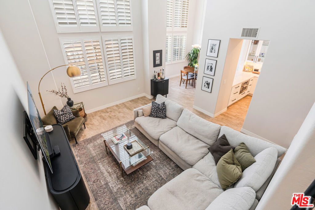 Welcome to this beautifully remodeled top-floor penthouse in the recently updated Coronado building. With nearly 1,900 square feet of light-filled living space, 3 full bedrooms, an office, and 2.5 baths, this home combines modern upgrades with exceptional functionality and style. Step into a grand, open-concept main level featuring soaring 18-foot ceilings and oversized windows that flood the space with natural light. The inviting living room flows seamlessly into a formal dining area and a beautifully updated kitchen, complete with matching stainless steel appliances, newer cabinets and quartz countertops, a generous breakfast bar, and a walk-in pantry. Just off the main living space, you'll find a dedicated office with custom built-ins ideal for working from home, along with a convenient powder room for guests. Upstairs, a versatile bedroom includes its own separate flex space/workout area and a bonus storage room. Downstairs, the expansive primary suite is your private retreat, featuring a walk-in closet and spa-inspired en-suite bath with dual vanities, a soaking tub, and a separate glass-enclosed shower. An additional guest bedroom with ensuite bathroom, and a laundry closet with newer washer and dryer complete the lower level. Additional highlights include two newer HVAC systems for optimal climate control, a south facing balcony, two garage parking spaces with access to EV charging, and a private storage bay. Located just minutes from The Resort, Whole Foods, Runway Playa Vista, Concert Park and top dining spots. This is more than just a home it's a lifestyle. Come experience the vibrancy, convenience, and charm that make Playa Vista one of L.A.'s most sought-after communities.
