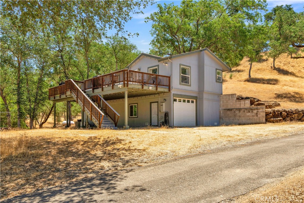 Discover a rare opportunity to own in the exclusive gated community of South Shore Village Club (SSVC), a private ski club resting along 3,300+/- feet of Lake Nacimiento shoreline. As a 1/40 owner of this 425-acre recreational haven, you will gain access to a leisurely lifestyle that includes boating, fishing, ATV riding, hiking, biking and even hunting across 375 dedicated acres which also has ranges on site and trap shooting. This two-story, on and off-grid home offers approximately 1,241 sq. ft. upstairs with 3 bedrooms, 2 bathrooms, a spacious kitchen and open living area which leads to a large 18x52 (over 900 sq ft!) deck perfect for outdoor entertaining and BBQ-ing at the end of a great day on the water! The main bedroom is spacious and includes ensuite bath with large soak tub and views of the surrounding forest, as well as dual sinks and walk-in shower. Downstairs features a fully insulated 700+/- sq. ft. garage with a workbench and 50 & 30 amp 220V outlets, and a BONUS 500 sq. ft. finished game room or optional guest quarters, climate controlled with a full bathroom. The property includes RV hookups, 2 access options for the home - one with stairs and a back entrance with no stairs! The home is also powered by a propane-fueled Generac for year-round security that you can keep the power on during any outages. SSVC members enjoy access to their own marina with boat slips, and numerous trails for hiking or biking. With only 40 memberships total, SSVC offers a private, close-knit atmosphere just under an hour from Paso Robles wine country, though there's many incredible wineries within just 20 miles of Running Deer in this beautiful West Paso Robles region! Whether you're looking for a weekend escape or full-time leisurely living, this home invites you to live, play, and explore in one of San Luis Obispo Counties most regarded lake communities.