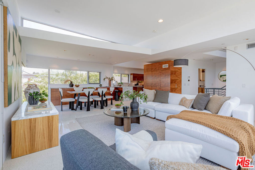 Fully Remodeled Modernist Townhome by Michael Folonis, one block from Main Street and two blocks from the sand, this iconic 3-bedroom, 3-bathroom townhome designed by celebrated architect Michael Folonis, FAIA offers a rare blend of architectural pedigree and thoughtful contemporary upgrades. Originally built in 2006 and recently enhanced with high-end renovations, the residence now features completely remodeled kitchen and bathrooms, blending timeless design with modern comfort. The kitchen showcases custom Claro Walnut cabinetry, creating a warm yet sleek contrast to the home's minimalist structure. New finishes elevate all three bathrooms, delivering a clean, spa-like aesthetic that complements the overall vision. Flooded with natural light and surrounded by glass, the open-concept living and dining areas are elevated to the second floor, offering an expansive, gallery-like space that opens to a private balcony. A versatile mezzanine loft above serves perfectly as an office, den, or creative space, and leads to a private rooftop deck with sweeping city and coastal views. What truly sets this home apart is its direct connection to the outdoors. A private yard extends from the primary suite, while a serene garden patio opens from both secondary bedrooms, creating a peaceful and livable experience that flows effortlessly between inside and out. Interior features include a harmonious mix of hardwood high end cabinetry and polished terrazzo tile flooring, high ceilings, and extensive custom cabinetry throughout. Additional highlights include 2-car side-by-side parking in a gated underground garage, in-unit laundry, and an unbeatable location at the crossroads of Santa Monica and Venice, close to the beach, cafes, boutiques, and the energy of Abbot Kinney. This is more than a home. It is a statement of architectural intent, now reimagined for modern coastal living. Small 3 unit building with earthquake insurance.