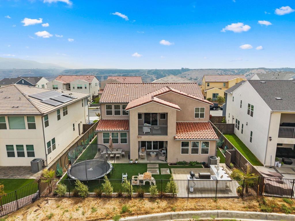 Discover modern sophistication and timeless design in this stunning 4-bedroom, 3.5-bath Shea home nestled in the highly sought-after Savona community of Côta Vera. Thoughtfully crafted for both entertaining and everyday living, this residence seamlessly blends contemporary style with exceptional functionality. Step inside to an open-concept floor plan filled with natural light from expansive windows that frame picturesque views at every turn. The gourmet kitchen is a chef’s dream—featuring extensive upgraded cabinetry, elegant quartz countertops, and walk-in pantry. Every detail throughout the home has been carefully curated, from the wide-plank luxury vinyl plank floors to the custom closets in three of the four bedrooms. The first-floor bedroom suite provides convenience and privacy for guests, while the dedicated office with custom sliding doors creates the ultimate work-from-home environment. With over $180,000 in premium upgrades, this home leaves nothing to be desired. Highlights include 12 fully owned solar panels, a whole-home water filtration system, a built in BBQ with a Traeger, and a Tesla charging station. Step outside to the covered patio, complete with a cozy gas fireplace and serene mountain views—perfect for quiet evenings or entertaining guests under the stars. This is more than a home—it’s a lifestyle of elegance, comfort, and sustainability in one of San Diego’s most desirable communities.