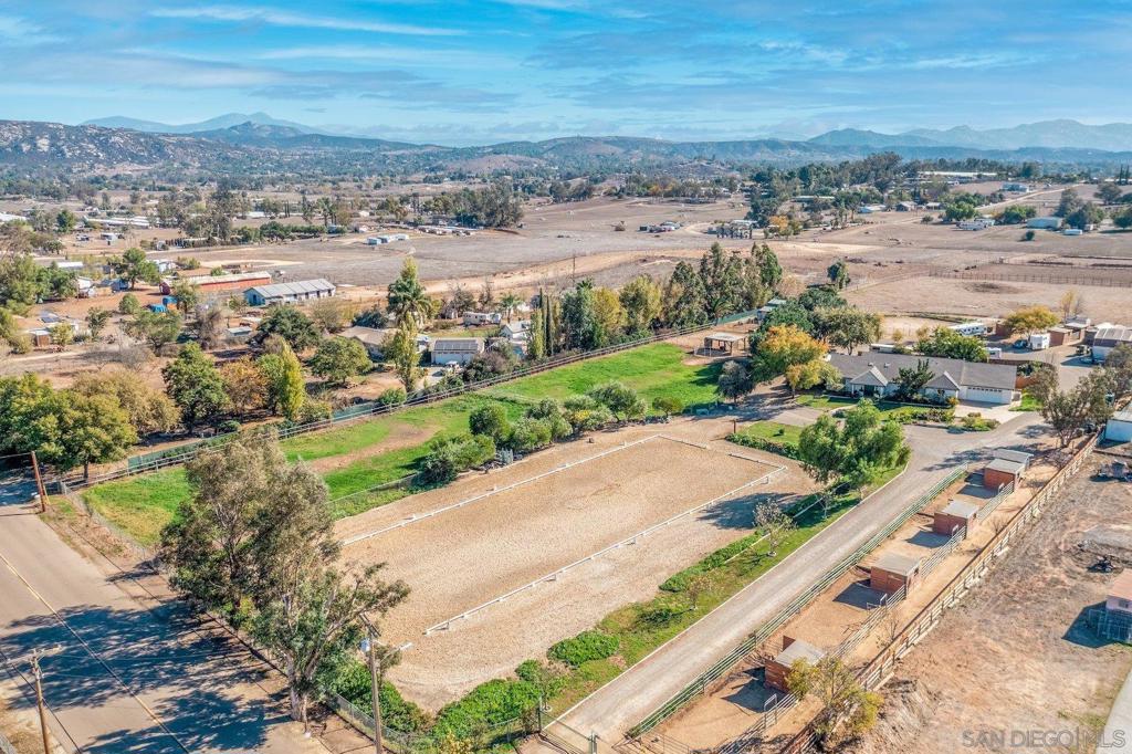 Rocking Horse Ranch is a beautifully maintained, all-usable, 4-acre equestrian property with the rare “O” animal designator making it ideal for horse businesses, kennels, or agriculture. Conveniently situated in a close-to-town Ramona location near San Pasqual Valley. The charming farmhouse was extensively remodeled in 2016 and features an open floor plan with 3 bedrooms, 2 bathrooms, a professional wood paneled office, grand kitchen with granite countertops, fantastic laundry area and financed solar. Top-tier horse amenities include a 205’ x 100’ irrigated arena with professional footing suitable for high level dressage or jumping, a breezy 6-stall barn with tack room, cross ties, and in & outs, irrigated grass pastures that are kept wonderfully green by a strong agricultural well, round pen, RV hookup, multiple fenced paddocks with shelters, and additional housing. Ready to enjoy and truly the perfect property for anything you desire!
