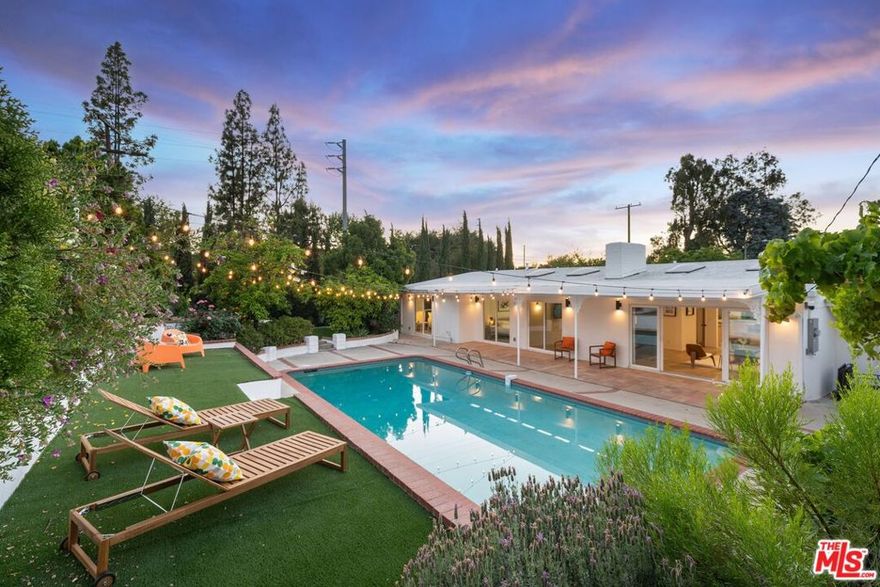 Tucked away at the end of a serene cul-de-sac in the coveted Woodland West development, this iconic residence, originally crafted by renowned architect Charles Du Bois A.I.A., effortlessly blends timeless mid-century architecture with elevated modern luxury. Gated for privacy and framed by an enchanting, grassy front yard dotted with mature, fruit-producing trees, the property makes a striking first impression. Step through dramatic double doors into a home that honors its architectural roots while embracing today's finest upgrades. Vaulted, beamed ceilings and Du Bois's signature double-sided fireplace anchor the sun-soaked living spaces, where skylights flood the interiors with natural light and white oak floors flow seamlessly throughout. The heart of the home is a stunning custom chef's kitchen featuring sleek white oak cabinetry, polished concrete countertops, luxury appliances and direct access to the garage for everyday ease. Meticulously upgraded throughout, the home boasts new electrical and plumbing systems, updated HVAC, EV charger port, a full security camera setup, whole-home audio with integrated speakers, and so much more. The private primary suite is a true retreat, complete with a large closet, direct access to the backyard, and a spa-inspired bath with a floating double vanity, soaking tub, heated floors, and a smart bidet toilet. Additional bedrooms are generously sized, with the Jack & Jill bathroom also offering heated floors and designer finishes. Step outside to an entertainer's paradise: a resort-style backyard with a sparkling pool, lush lawn, mature fruit trees, and a charming, vine-covered outdoor dining area. Lounge beneath the covered patio, soak in the sun from the upper yard, or enjoy the garden-like serenity surrounding you. Perfectly located just minutes from the best of Woodland Hills, Calabasas, and Malibu with premier shopping, dining, houses of worship, and convenient 101 freeway access. Great schools including top-rated Calabash Elementary, with the option to waiver into Calabasas schools. A rare offering, curated by designer and builder Gregory Storm, where architectural significance meets luxurious Southern California living. Welcome home.