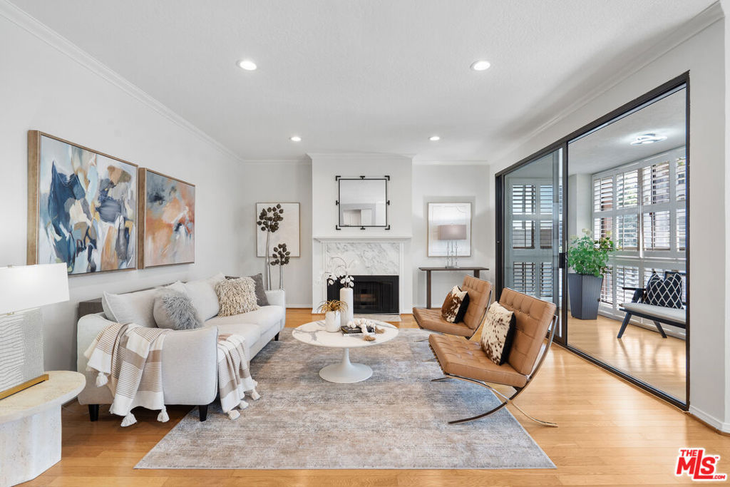Experience luxury living in this beautifully remodeled 3 bed, 3 bath top-floor southeast-facing corner unit in a prestigious Hancock Park complex. Thanks to its unique position, only one shared walls with neighboring units, offering exceptional privacy and abundant natural light throughout. With nearly 1,800 sq ft of thoughtfully designed space, the open-concept layout features recessed lighting, hardwood flooring, and floor-to-ceiling windows that flood the home with light. The living room boasts a cozy decorative fireplace and an atrium-style glass-enclosed balcony ideal for morning coffee or evening relaxation.The remodeled kitchen is a chef's dream, featuring quartz countertops, a spacious island that opens to the living area, and premium Bosch appliances. Additional custom cabinetry lines the kitchen and dining area, offering ample storage and superb functionality. Every window is fitted with classic wood plantation shutters, and the entire interior has been freshly painted for a modern, inviting atmosphere. The primary suite is generously sized with a walk- in closet and spa-inspired bath with double vanities, a soaking tub, and a separate shower. Two additional bedrooms also enjoy great closet space and easy access to full baths. Extras include in-unit laundry, two side-by-side parking spaces, and a large private storage unit. Community amenities include security, a heated pool, spa, sauna, clubhouse, and fitness center. Located within the desirable Third Street Elementary School District, this home is close to the best of Hancock Park dining, shopping, and more. This is a rare opportunity to own a top-floor, sun-drenched, corner unit with unmatched privacy in one of LA's most sought-after neighborhoods.