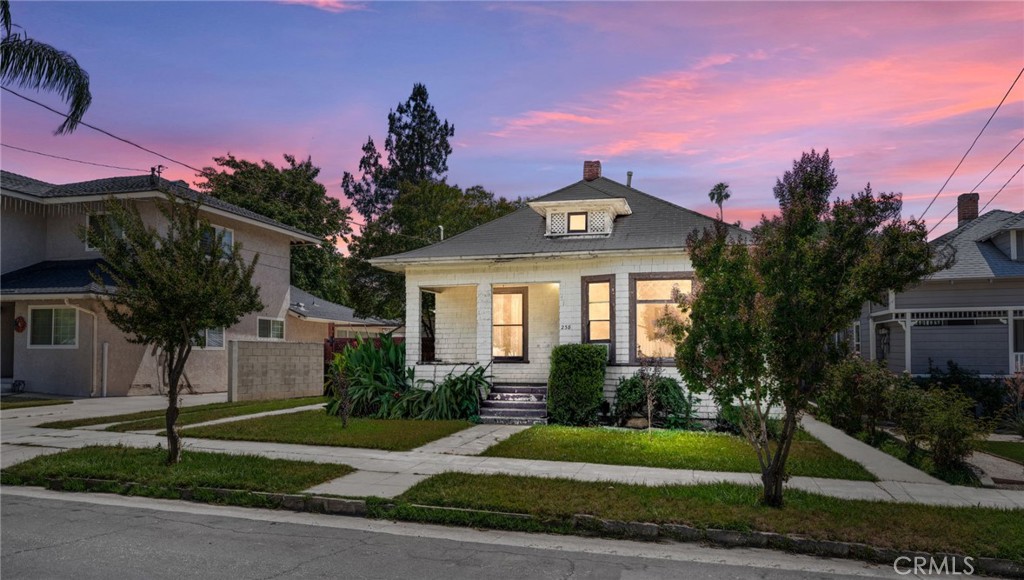 Great opportunity in South Redlands walking distance to downtown shops and dining! This property offers all the charms of a classic Redlands home, with room to make it your own! The entry begins at a spacious front porch, great to accommodate a bench or small table and chairs for enjoying your morning coffee. Enter into a light and bright living room featuring original bay windows. Home features wood flooring throughout. The first bedroom branches off the living room, and a formal dining room sits between the living room and kitchen space. The two additional bedrooms both connect to the pass through bathroom with a clawfoot tub and characteristic tile and wall paneling. An expansive yard would be ideal for building a pool or enjoying a garden; there is also great potential for an ADU or a sizable garage! On the side of the home, a gated covered carport is wired for electric car charging. The location is directly across the street from the YMCA, and just down the street from Citrone Italian Chophouse. Excellent Redlands Schools. The home is ready for some repairs and renovations, and is being sold strictly as is.