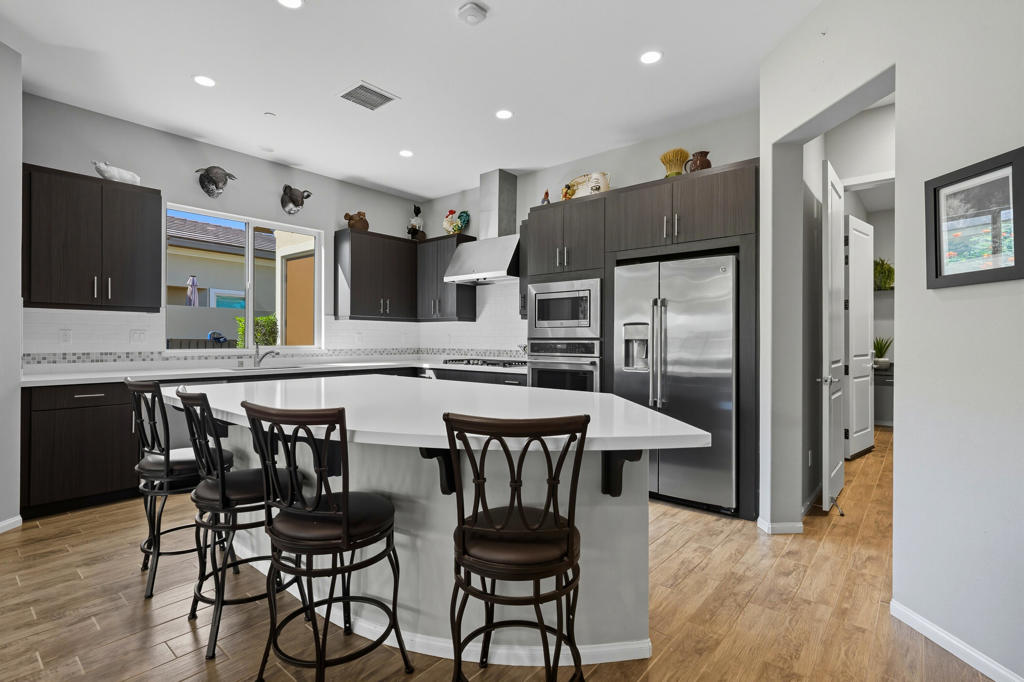 Stunning, Highly Upgraded Home in Polo Club -- 82595 Ladder Canyon Dr, Indio, CA 92201Welcome to this exquisite, move-in ready residence offering exceptional upgrades throughout and a resort-style entertainer's backyard. Built in 2018 and set on a 7,405 sq ft lot, this 2,451 sq ft single-story home delivers luxury, comfort, and striking design. Redfin+1From a private courtyard entry, step into an open Celebrare floor plan where dramatic sight lines guide you through expansive living spaces. The huge great room features a cozy sitting area with fireplace, perfect for gatherings or relaxing evenings. Wood tile flooring flows through all the common areas, with plush carpet in the bedrooms for warmth underfoot. There is a 15' rolling glass door that connects to the patio offering the best in indoor/outdoor living.The chef's kitchen is a culinary masterpiece, boasting stainless steel appliances, built-in cooktop with vent, quartz countertops, custom backsplash, and designer finishes throughout. Entertain effortlessly while prepping meals -- this is kitchen perfection.Retreat to the large master suite, boasting ample space and direct yard access. The upgraded primary bath impresses with a designer shower, large soaking tub, and dual vanities with premium countertops -- a true spa experience.Outside, enjoy a south-facing rear yard that bathes the space in natural light. The pool & spa feature a raised waterfall, wrapped by a large covered patio for indoor-outdoor living. Lush landscaping frames the property, creating a private sanctuary atmosphere.Additional highlights include a 3-car garage with electric car charging station, premium upgrades throughout, and thoughtful attention to detail in every room. This property is the perfect balance of sophistication and comfort -- your dream home in the heart of Indio awaits.This home is located just down the street from the 25,000 sq ft Polo Club clubhouse. A transferable membership (buyer to pay $1,875 fee) provides access to world-class amenities including a fitness center, tennis, pickleball, resort and lap pools, indoor golf simulator, and the acclaimed June Hill's Table restaurant. All set against the stunning backdrop of the Santa Rosa Mountains.