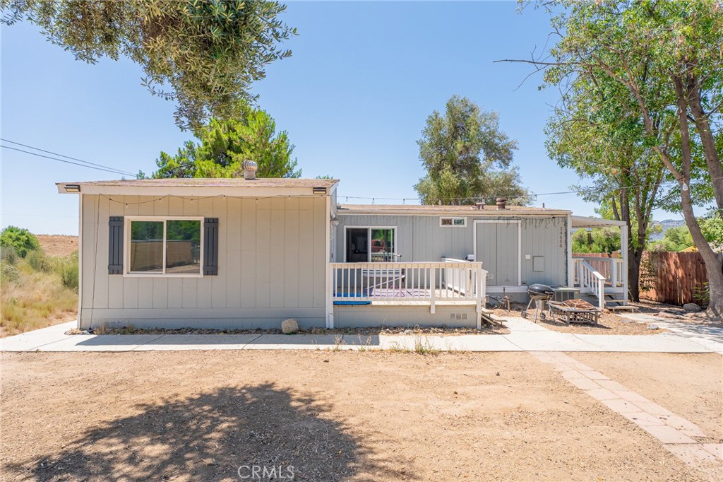 Welcome to this charming manufactured home on land, offering the perfect blend of comfort and convenience. Situated on a permanent foundation, this home qualifies for traditional financing and provides lasting stability. Inside, you’ll find an open floor plan with a mix of laminate wood flooring and plush carpet. The kitchen features white cabinetry, granite countertops, and plenty of space for meal prep and entertaining. A stylish barn door adds a touch of character in the family room. Attached unit with sliding glass door and own porch that could be used as another room, office or storage. Relax on the spacious front porch and enjoy the oversized lot, ideal for outdoor activities or future additions. Located in a more rural setting with a peaceful atmosphere, yet still conveniently close to freeways and shopping.