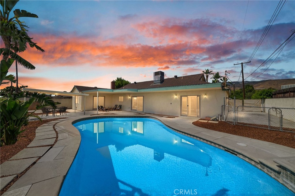 Single story, turnkey Highland pool home with an attached two car garage and gated RV parking! Located just minutes from Yaamava and the 210, this classic ranch is on a nice street in a great commuter location. You're greeted by a drought resistant front yard with new landscaping. Enter the home through the front door, or directly from the attached garage with a brand new door. The kitchen, with white cabinets and stainless appliances, is adjacent to a family room that opens up directly to the back yard via a sliding glass door. A sizable covered patio provides a great space for your summer pool parties, and there is an additional covered seating area as well. Heading back through a second slider, you'll find a family room currently staged for dining off of the formal living room with a fireplace. These living areas are opposite the four bedrooms, which is great for entertaining. The primary bedroom has a bathroom with walk in shower and a brand new vanity. It also features direct yard access. The walled yard feels very private, and the RV parking space is behind a chainlink fence for added security. This home also features upgraded dual pane windows throughout and central AC.