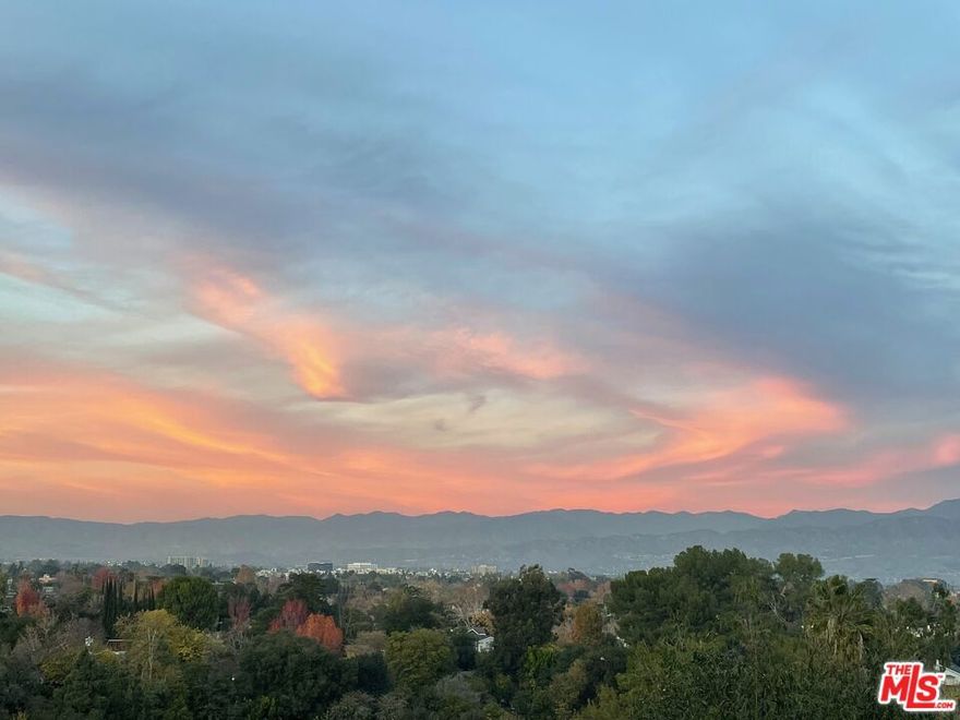 Perched in the hills of Studio City, this exquisite residence captures sweeping 180 valley views that stretch endlessly across to the mountains. Designed for a seamless blend of elegance and comfort, the home invites you to experience true California living, with expansive decks and sun-filled interiors that frame the stunning vistas from nearly every angle. A wide lot with a side yard enhances the sense of space and privacy, while the garage conveniently positioned near the street and entry level offers ease of access without compromising the home's hillside setting. Inside, a rare floor plan showcases three spacious bedrooms, each with its own en-suite bath a layout as functional as it is refined. Recent upgrades elevate the property to turnkey perfection, including a new roof, HVAC system, and tankless water heater, along with fresh paint inside and out and beautifully refinished hardwood floors. This home is more than a residence it's a lifestyle. Whether entertaining against the backdrop of the valley lights, enjoying quiet moments of retreat, or raising a family within the highly sought-after Carpenter School District, every detail has been designed to inspire. Just moments from Ventura Boulevard, you'll enjoy easy access to the Studio City Farmers Market, fine dining, boutique shopping, and everyday conveniences. With its rare combination of panoramic views, thoughtful design, and premier location, this is a truly exceptional offering.