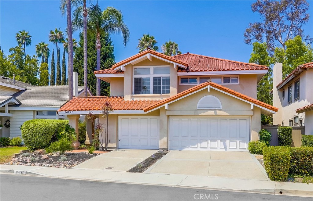 This elegantly appointed two-story home combines timeless design with modern comfort, offering four bedrooms and three bathrooms in a bright, open layout. A versatile downstairs bedroom with an attached bath—currently used as an office—does not have a closet but could easily be converted into one, making it ideal for guests or a private workspace. The formal living and dining rooms feature soaring vaulted ceilings, French doors, and abundant natural light, while hardwood flooring flows through the kitchen and family room, where a cozy fireplace adds warmth and charm. The spacious kitchen is designed for both everyday living and entertaining, complete with a large center island, double ovens, refrigerator, and bar area. A convenient downstairs laundry room with sink adds functionality, and the two-car garage provides extra flexibility with two bonus rooms perfect for storage, an office, or hobby space. Upstairs, the expansive primary bedroom boasts faux-wood flooring, a generous closet, dual sinks, soaking tub, and separate shower, with two additional oversized bedrooms and another full bath. The private, low-maintenance backyard offers the perfect outdoor retreat. Set in a quiet neighborhood just a short walk to Barbadanes Park, this home is centrally located near shops, excellent schools, Lake Mission Viejo, the Country Club & Golf, with easy access to freeways and toll roads—an ideal blend of comfort, style, and location.