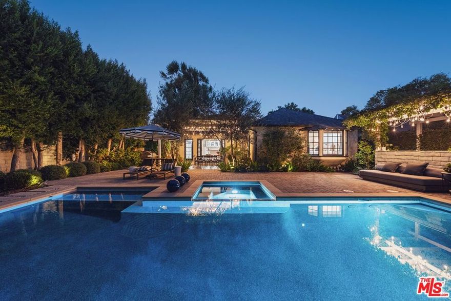 Located in the heart of Longridge Estates, this single-story completely updated traditional residence embodies timeless sophistication, complete privacy, and effortless livability. Behind secure gates, the home reveals a serene retreat surrounded by lush, mature landscaping, an entertainer's paradise and a private sanctuary all in one. Step inside to discover wood-beamed ceilings, herringbone-patterned floors, designer lighting, French doors, and elegant fireplace mantels that showcase the home's refined craftsmanship. The thoughtfully designed layout, a true traditional floor plan rarely found today, allows each room to maintain its own character while flowing seamlessly together, perfect for both intimate gatherings and large-scale entertaining. A formal living room anchored by a stately fireplace welcomes guests just off the entry, while the spacious family room with built-in wet bar, additional seating, and direct patio access sets the stage for effortless entertaining. The formal dining room, with seating for eight-twelve beneath a statement chandelier and bay windows, connects beautifully to a well-appointed kitchen featuring stainless steel appliances, shaker-style cabinetry, and generous storage. The primary suite offers a tranquil retreat bathed in natural light, complete with a walk-in closet and a spa-inspired bathroom boasting dual vanities and a large frameless glass shower with custom tilework. Two additional guest bedrooms and a full bath provide comfort and flexibility, while two half baths add convenience throughout. Outdoors, the property transforms into a resort-like escape with a sparkling pool and spa surrounded by manicured greenery, multiple lounging and dining areas beneath a pergola, and an expansive patio ideal for hosting under the stars. The fully gated grounds provide the ultimate sense of seclusion, while the front courtyard offers additional seating areas for quiet reflection or casual conversation.