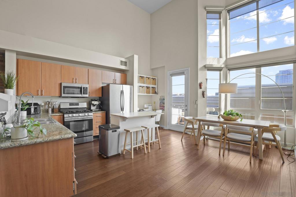 Live the Loft Life! A Rare Find in Union Square! Top-floor condo featuring a two-story loft design with soaring ceilings. Floor-to-ceiling picture windows flood the home with natural light, complete with upgraded motorized shades, both light-filtering and blackout. Open-concept floor plan with a contemporary brick accent wall, engineered hardwood floors, and a spacious kitchen with granite countertops, stainless steel refrigerator, and gas range. Step outside to your balcony and take in the skyline views - perfect for morning coffee or evening relaxation. Newer washer and dryer. One assigned parking spot. Cage storage in the garage. Union Square is a well-managed HOA that offers resort-style amenities: a gym, hot tub, sauna, community room, and electric car charging - ideally located in East Village—adjacent to City College, near restaurants, and Petco Park - easy freeway access (5, 94, 163). With major redevelopment underway in East Village, now is the time to buy. VA approved and ready for its next owner. Turnkey, ready to move in. Live the loft life today!