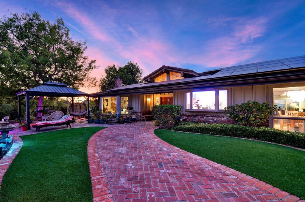 Perched atop a private Poway mountaintop on just over one acre, this 3,750 sq. ft. single-level residence captures 270° panoramic views of mountains, valleys, and twinkling evening lights. Designed for both serene living and sophisticated entertaining, the home offers four bedrooms, 3.5 baths, and a thoughtful split-bedroom layout for privacy. The remodeled chef’s kitchen features Wolf appliances, a $20K Sub-Zero refrigerator, a six-burner gas range with pot filler, dual ovens, a convection microwave, a warming drawer, a workstation sink, and Brazilian stone counters with a waterfall edge. Soft-close European cabinets, custom lighting design, and generous storage elevate the space. Expansive living areas showcase exposed-beam ceilings, two wood-burning gas fireplaces, and seamless flow to outdoor spaces. The primary suite offers a private retreat, five view-filled windows, and direct access to koi ponds and tranquil gardens. Resort-style grounds include a large pool and spa with colored lights, a volleyball setup, two redwood gazebos, a koi pond with a waterfall, a lemon tree, walking paths, and multiple vantage points for breathtaking sunsets. The three-car garage with a partial workshop, a wide driveway, and ample storage completes the package. Located minutes from top-rated schools, local wineries, and convenient amenities, this property blends privacy, prestige, and the quintessential Southern California indoor-outdoor lifestyle. ****SEE THE MATTERPORT TOUR HERE ON THE MLS! SELLER STATES THE FOLLOWING HOME IMPROVEMENTS: Over $300 K in upgrades $150 K Custom Kitchen $ 60 K flooring Hardwood carpet and ceramic tile in Master bath (had dirty white carpet) long tiles. $ 27K landscaping, painters handyman window washers (labor plus six big urns). $10K front gazebo, pavers and artifial grass $ 7 K retiling pool and spa / $4k heater $14 K long, extra deep lattice fencing $ 15 K back gazebo $ 1,500 chandilier enteryway $ 2,300 bidet smart toilet and seat in master $ 2 K Hunter blinds $ 2 K colored in front room and inset lights in master $ 3 K wired in security camera (3 outside, 3 inside) $ 2 K outside collored lights and labor $ 3 K plants and bushes and trees $ 1 K new smart thermostat