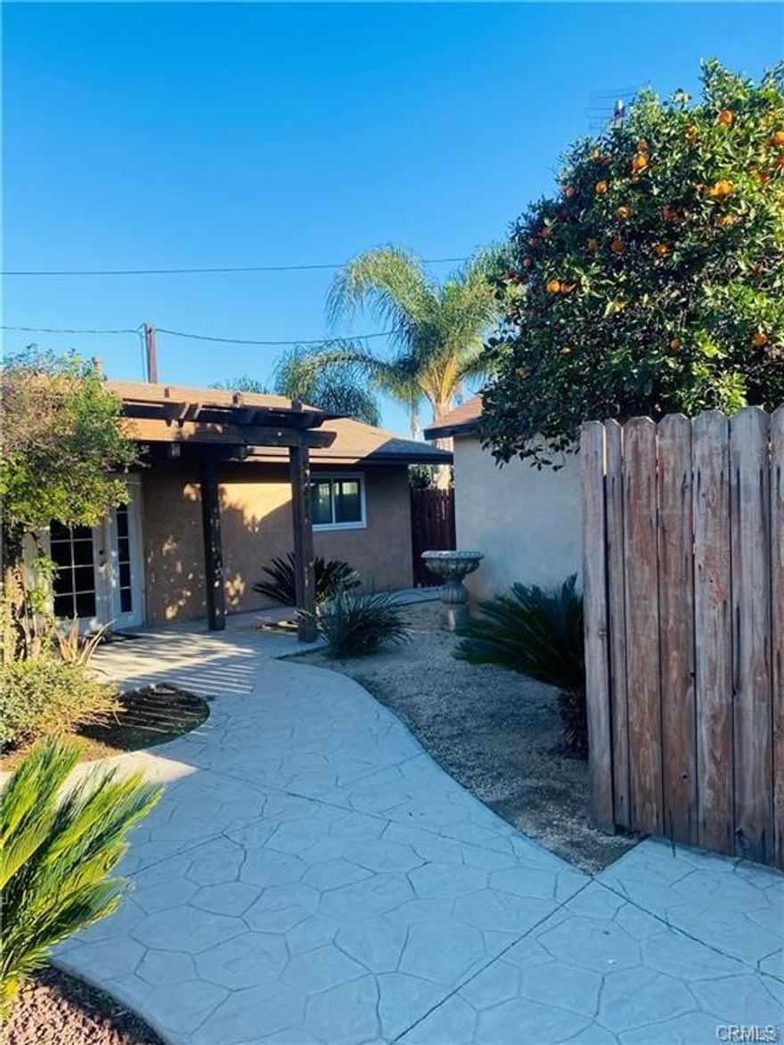 Discover this charming single-story 2-bedroom, 1-bathroom unit tucked away in a peaceful setting surrounded by lush greenery and desert-inspired landscaping. Located within a gated property, the home offers a tranquil atmosphere while still being centrally located with easy freeway access and walking distance to Home Gardens Elementary School. Enjoy the ease of a shared walkway leading to the duplex, plus a dedicated driveway parking space with plenty of street parking available for guests. Inside, the unit features brand-new flooring and freshly refreshed paint, creating a clean and inviting space. Appliances include a stove/oven, refrigerator, and in-unit washer & dryer, with water, trash, and sewer services included in rent for added convenience. This is a non-smoking, pet-friendly property.