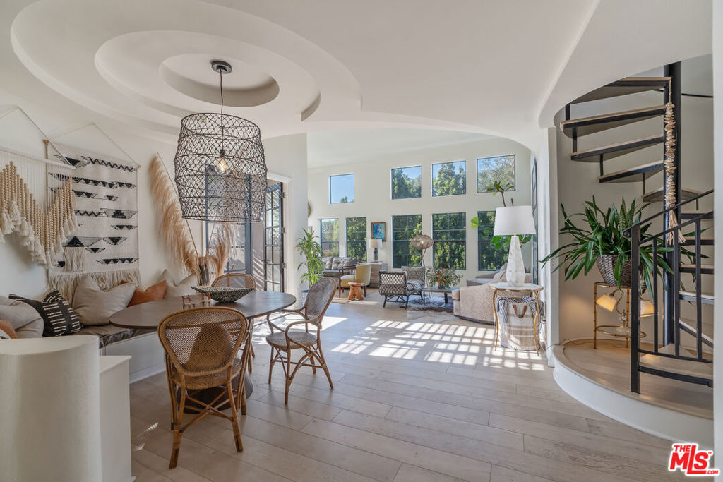 Sun-drenched Mediterranean Penthouse with sprawling private rooftop retreat. Peacefully tucked away in the top rear corner of a boutique Mediterranean building overlooking Beeman Park, this light-filled penthouse is a timeless ode to Spanish-style elegance. Architectural ceilings and ornamental finishes blend seamlessly with modern updates, creating a sanctuary that feels both warm and refined in the heart of convenient west Studio City. Inside, soaring 12-foot ceilings and a dramatic wall of windows bathe the space in all-day natural light, elegantly framing sweeping views of the San Gabriel Mountains and mature treetops. Curved walls, double-stacked crown molding, and a cozy gas fireplace add warmth and character to the expansive living space, while a modern open-concept layout places bedrooms on opposite sides for optimal privacy. French doors open wide to a spacious terracotta-tiled patio with unobstructed western exposure, creating a seamless indoor-outdoor flow perfect for working from home, dining or unwinding at sunset. A dramatic spiral staircase leads directly to your own 2 oversized private rooftop deckstotaling over 500 square feet of versatile living spaceand offering stunning 360-degree panoramas of the Hollywood Hills, mountains and beyond. Whether hosting friends, stargazing over a fire pit, or simply enjoying golden-hour light, this space is a showstopper. Thoughtful upgrades include 7-inch wide-plank engineered hardwood floors throughout, built in dining banquet with hidden storage, fully replaced HVAC, newer stainless steel appliances, in-unit laundry, and a dedicated EV charger for your two tandem parking spaces. The building features breezy open air atrium hallways adorned with slate tiles, overlooking a serene central fountain, and is just steps from Beeman Park's tennis and basketball courts, baseball fields, playground, trails, and brand new community recreation center. Following the treelined sidewalks of the neighborhood will lead you to lively Ventura Boulevard and The Shops at Sportmen's Lodge: where an abundance of upscale dining, shopping, and conveniences awaitErewhon, Equinox, Sugarfish, Alfred's Coffee, Joan's on Third, Ventura Place Farmer's Market, Trader Joe's and Whole Foods are only a small sampling of the nearby amenities. Just a short distance away, escape into tranquil nature and enjoy breathtaking views of the San Fernando Valley at local hiking favorites Fryman and Franklin Canyon.A rare combination of privacy, character, and conveniencethis is Studio City living at its finest. Situated between Laurel and Coldwater Canyon, for direct access into West Hollywood and Beverly Hills, and just minutes south from the 101 freeway for easy access to the east and west sides of LA.