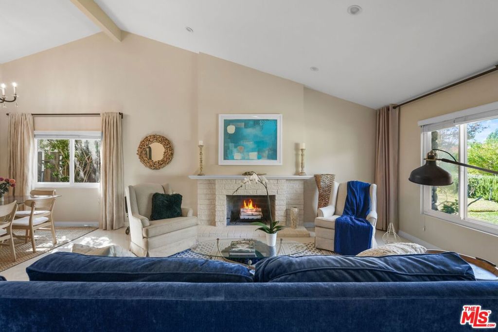Canyon Calm, Modern Soul  A Viewridge Estates Sanctuary. Tucked within Topanga's beloved Viewridge Estates, where canyon breezes mingle with the scent of sage and sun-warmed earth, this exquisitely remodeled four-bedroom, three-bath residence captures the rare alchemy of natural serenity and refined modern living. Here, 2,100 square feet of open, light-filled design unfold across a generous corner lot of nearly 10,000 square feet, a home that feels both intimate and expansive, grounded and elevated, casual yet undeniably sophisticated.Inside, soaring vaulted ceilings and cool porcelain tile floors create a rhythm of space and stillness, while a sleek gas fireplace anchors the living room in quiet elegance. The newly reimagined kitchen is the heart of the home, a culinary atelier outfitted with professional-grade appliances, custom cabinetry, and soft LED lighting that glows like twilight through the wide sunlit windows. It's a space that inspires gatherings, laughter, and the slow ritual of morning coffee in the breakfast nook as the canyon wakes around you.Two luxurious primary suites, each with a serene, spa-like atmosphere and elegantly updated baths, offer ultimate flexibility for multigenerational living, remote work, or gracious guest stays. Every detail feels intentional, from the recessed lighting that traces the architectural lines to the thoughtful updates beneath the surface: copper plumbing, an upgraded electrical panel, and energy-efficient fixtures that blend sustainability with style.Beyond the glass doors, a vast backyard stretches beneath the Topanga sky, a sanctuary for entertaining under the stars, cultivating a garden, or swinging gently beneath the trees as the day drifts away. Fruit trees nod in the breeze, and there's ample room for play, for parking, for life, all framed by the soft silhouette of canyon ridges. The spacious carport can serve as a relaxing space, as well. With RV parking, a two-car carport, and EV charging already in place, the property balances rustic charm with modern readiness.Location, too, tells its own story: a mere ten minutes to the culture and convenience of Woodland Hills and Calabasas, twenty minutes to the wild beauty of Malibu's coast, and steps from the hiking and biking trails that weave through the Santa Monica Mountains. It's a home that offers the best of both worlds, where nature hums just beyond your door, yet every comfort and connection lies within easy reach.In Viewridge Estates, life moves at a gentler tempo. Mornings begin with golden light spilling through vaulted spaces, afternoons unfold beneath oak-dappled shade, and evenings close with the hush of crickets and the scent of jasmine. This is more than a home, it's a modern canyon refuge, designed for those who seek calm without compromise, beauty without pretense, and a seamless harmony between the soulful and the contemporary.