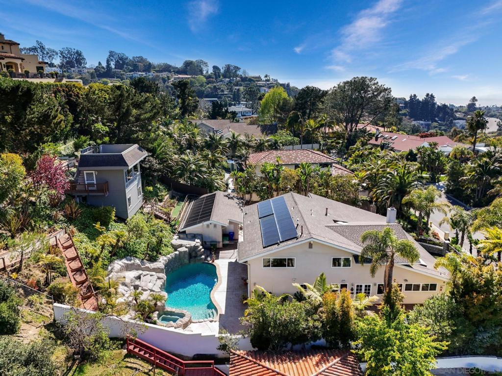 Discover the ultimate La Jolla lifestyle at this beautifully refreshed retreat in the Muirlands, set on a near-half-acre lot. Step inside to soaring cathedral ceilings, a grand living and dining area, and French doors that open to multiple outdoor entertainment spaces in the resort-style backyard with pool and spa, waterfall and slide — solar-heated for year-round enjoyment.The home also boasts three family gathering rooms, a dedicated office, a three-car garage and ample additional parking. A detached ADU is freshly painted and presents the property’s breathtaking ocean views to guests. Gated for privacy, the sprawling residence with grounds is a peaceful retreat above La Jolla’s best beaches, shops and dining.
