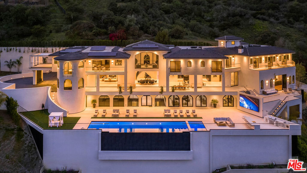 Rising above the Hotel Bel Air in the heart of the most exclusive neighborhood in the world, The Estate on Somma is a modern Spanish Revival masterpiece that redefines luxury living. Undoubtedly one of the most spectacular private residences in the world, this masterfully constructed work of art spans 40,000 square feet and features 8 bedrooms, 21 bathrooms, and an endless array of awe-inspiring amenities. Impressive and unforgettable, this extraordinary estate encompasses a private oasis that fulfills every desire for luxury. Neighbors include some of world's most famous and accomplished icons, however, The Estate is undoubtedly the Star of the neighborhood. Proving the developer's commitment to excellence, 15,000 square feet was acquired from the neighbor to redesign the approach completed end of 2023. In fact, every detail of this majestic mansion was carefully considered to deliver a life of luxury beyond compare. Upon entering, the grand scale and panoramic views will take your breath away. A sweeping staircase winds down like a sculpture and evokes a feeling of power and prominence. Floor to ceiling glass pocket doors frame panoramic views and flood the open floor plan with light and warmth. Luxurious details are mesmerizing and revealed at every turn. A chef's dream kitchen stuns with arched windows, high-end appliances, St. Laurent marble, and a massive island. Large scale living rooms have soaring ceilings and dramatic floor to ceiling windows that reveal bird's-eye views of the Bel Air landscape. Friends and family will cherish an invite and can be comfortably hosted in 8 large and luxurious bedrooms. Defining entertainer's dream, The Estate features amenities that rival the finest resorts in the world including a 36-person theater, multiple kitchens, eight bars, a professional basketball court, 1200+ bottle wine cellar with a wine tasting room inside & above and recording studio. A monumental auto gallery is incredible, and custom designed to showcase an entire car collection. The luxurious wellness center astonishes with a 75' indoor pool, sauna, steam room, hair salon and fitness studio. Outdoors, park-like grounds feature multi-level terraces, a jaw-dropping infinity edge pool/spa, weather-proof Samsung sign wall, and a kitchen for entertaining. No expense was spared to deliver this legacy property to the most discerning buyer. The floors have been newly sanded and stained, and the addition of a beautiful portico by the pool elevates the outdoor living experience. Technologically advanced smart home system w/ dual ISP's and a state-of-the-art security system that provides safety and convenience. With ample accommodations for staff including maid's quarters, and a security room, this extraordinary estate is nothing short of legendary. LLA completed in 2023 lot is over 73,000 sf.